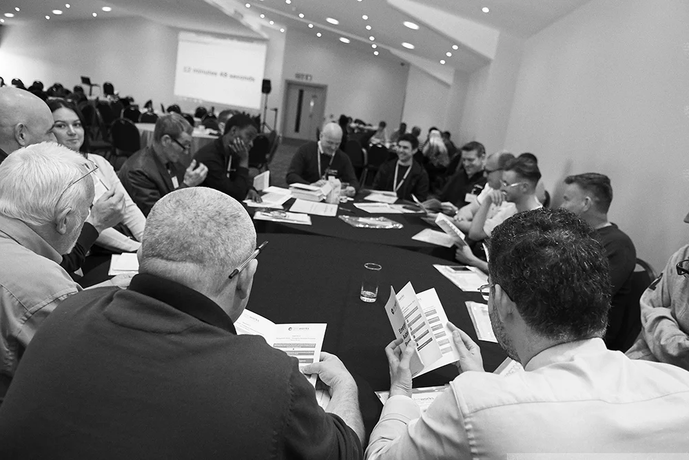 Black and White photo of a group of employees engaging in talks