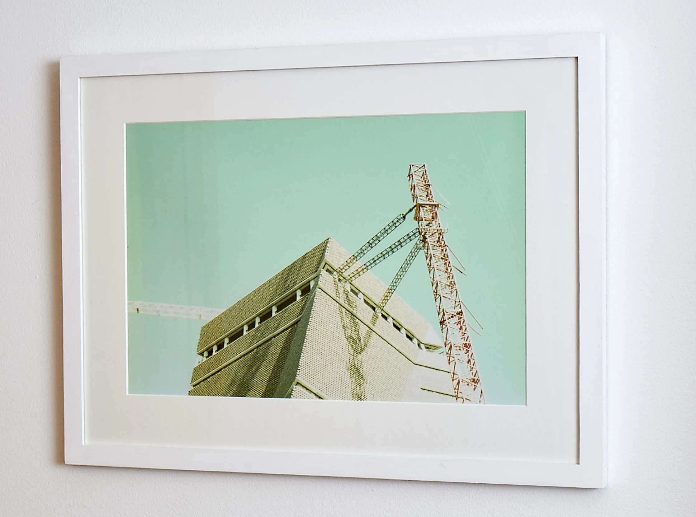 Tate Addition The simplicity of the white frame sets off the unique hues of this cross-processed print. Shot whilst the new wing of the Tate Modern was being erected, it is unlikely to ever be reenacted! Cross-processed image on Textured paper. Frame Size approx. 22x 16.5" COST £60.00