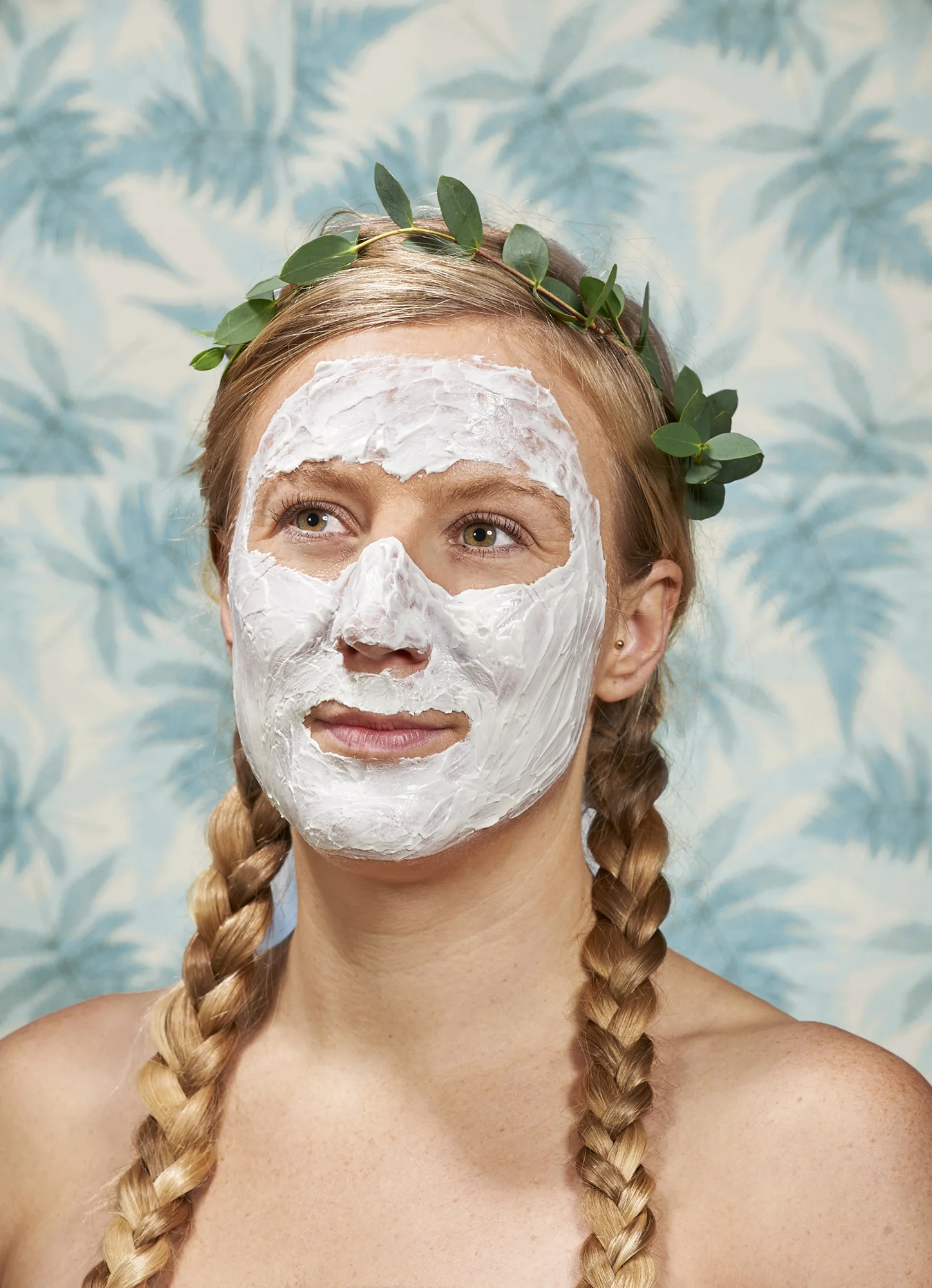 Portrait of a lady with blonde, plaited hair, wearing a facepack