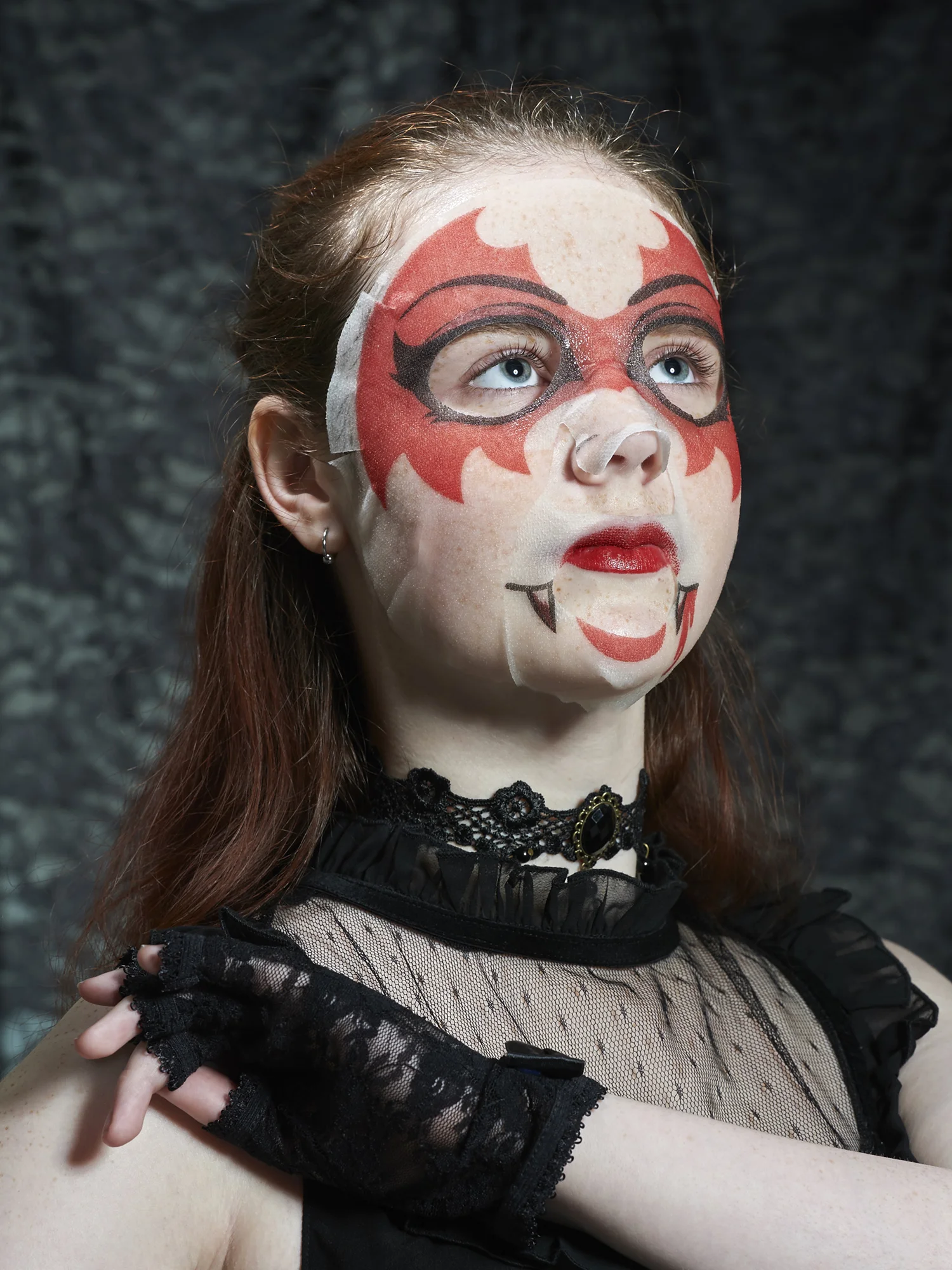 Quirky portrait of teenager with a face-mask in a vampire style