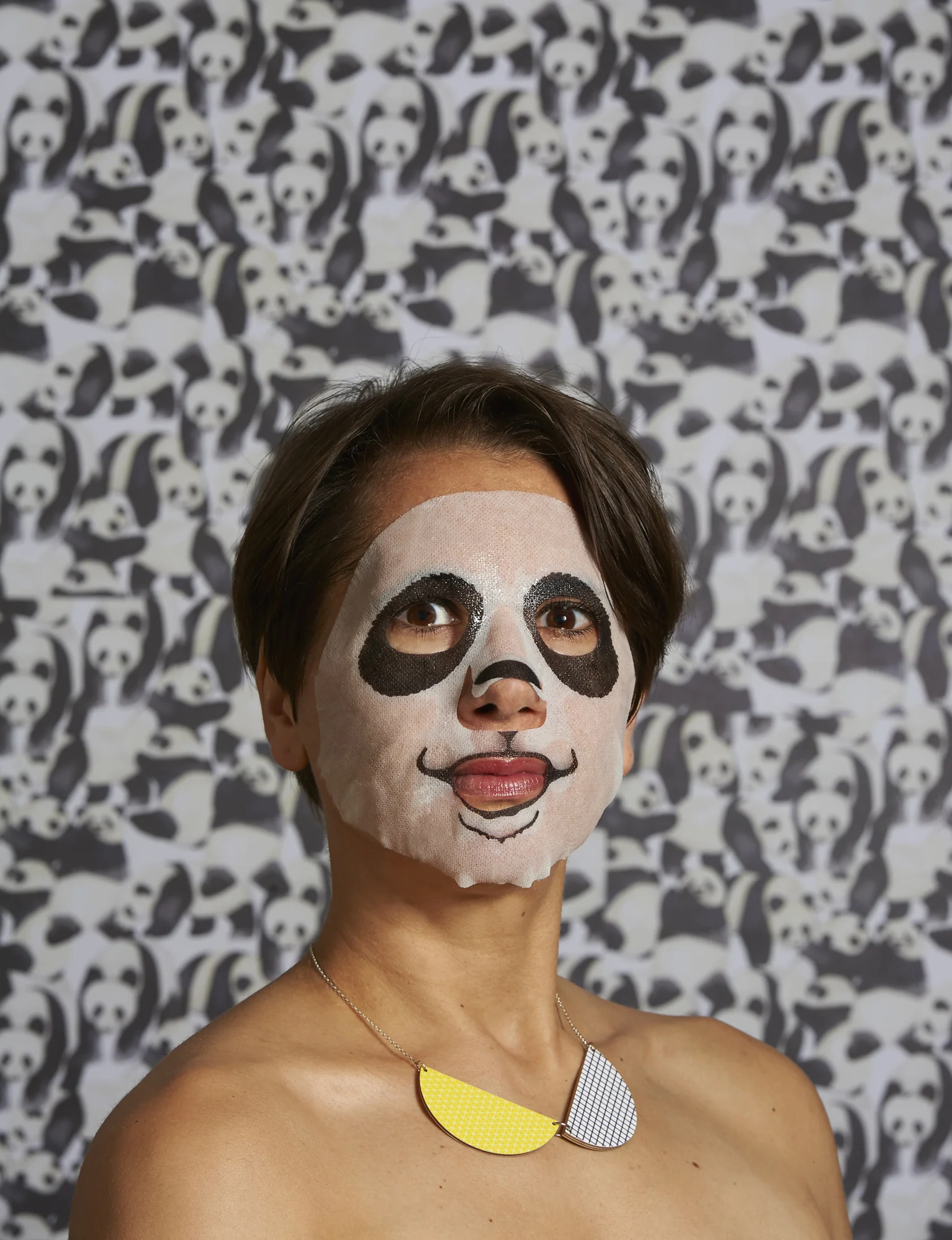 close-up portrait of a woman wearing a Panda-themed face pack