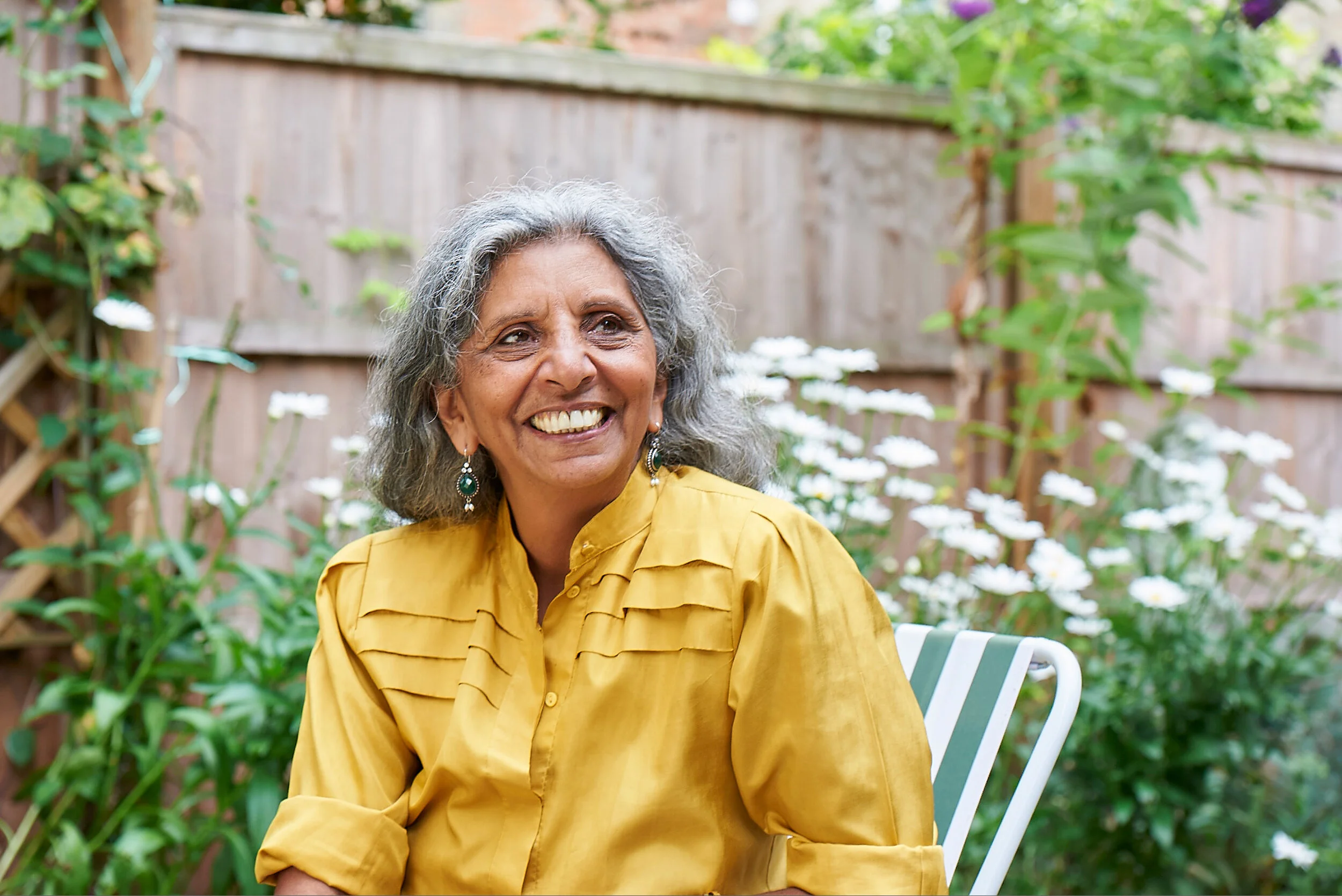 A photograph of an older lady with a beaming smile: shot outdoors