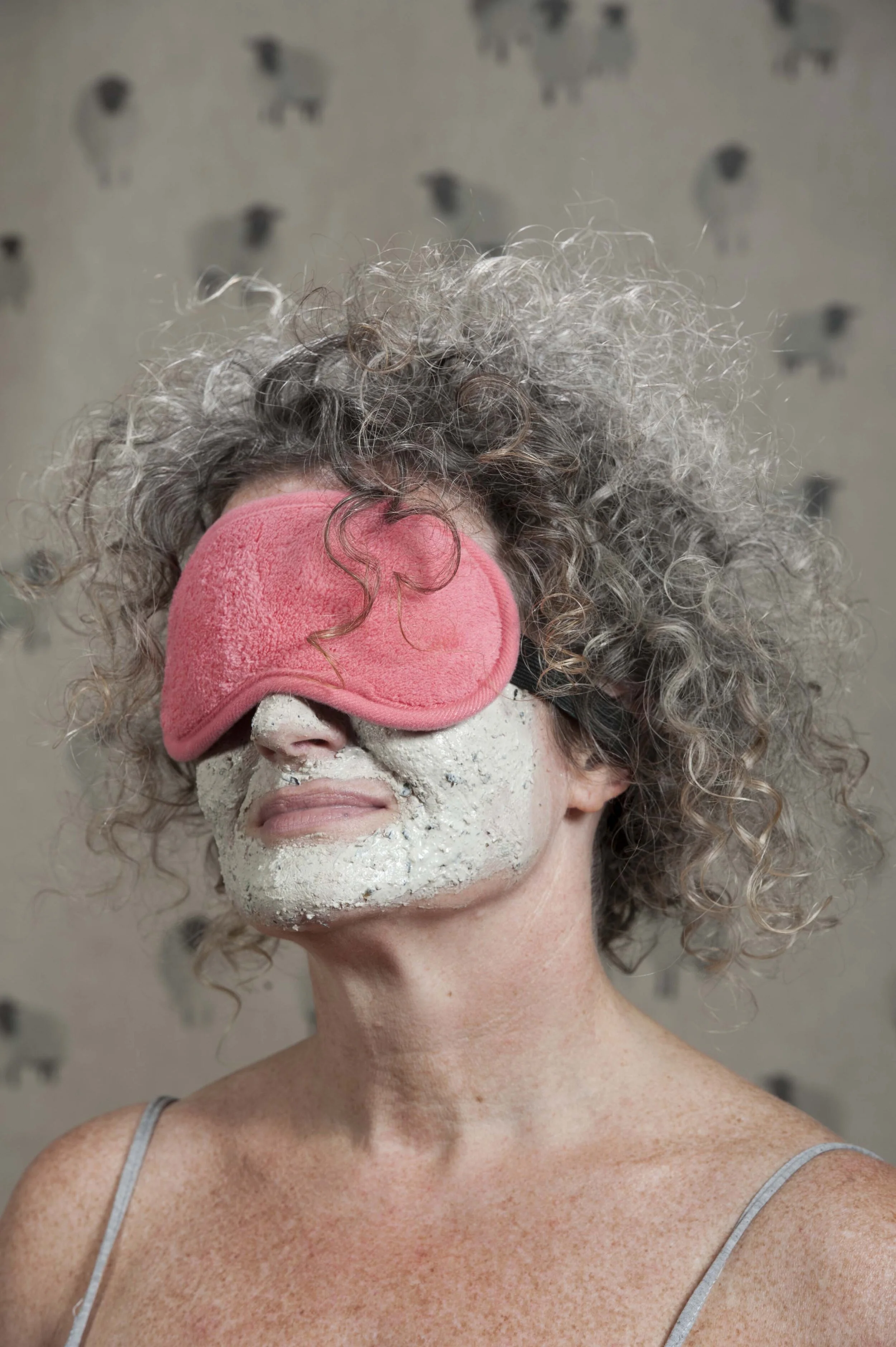 Woman in a cosmetic face pack and eye-mask