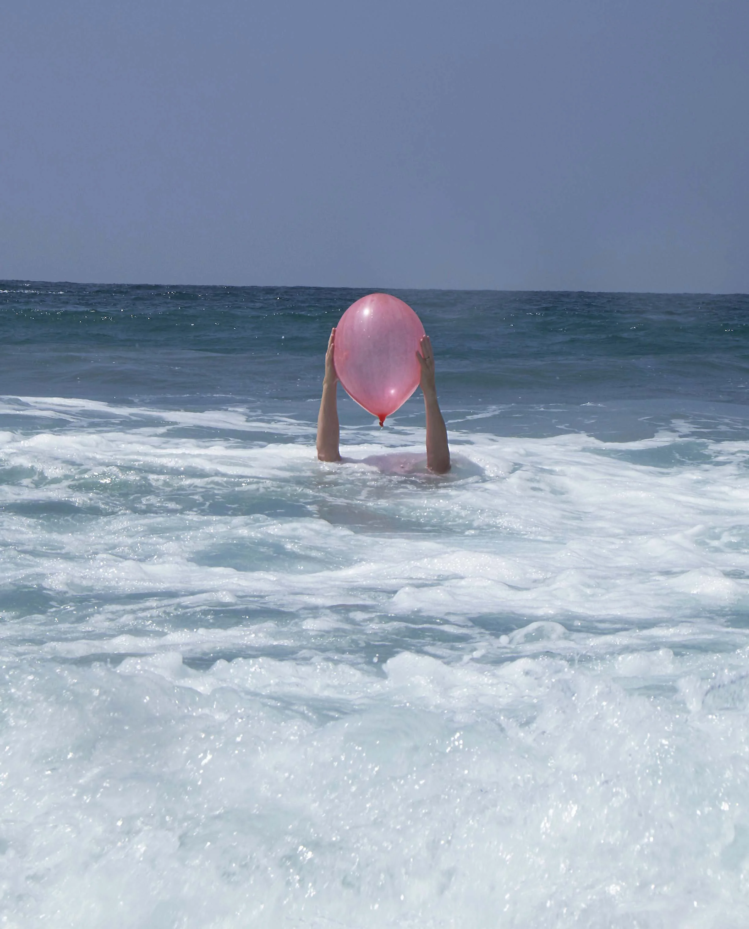 Stunning photo of man holding balloon in the pacific ocean 