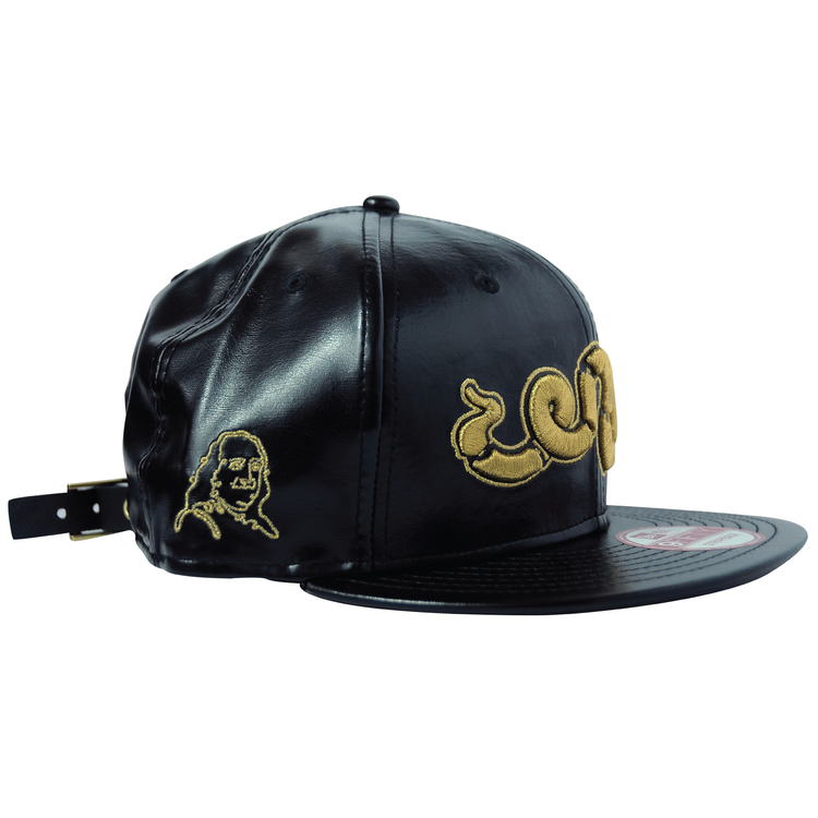 A black leather cap with gold embroidery of a cartoon character's face and stylized text.