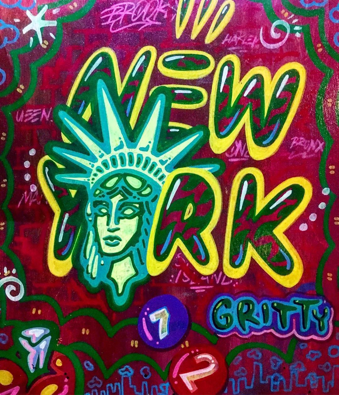 Bright, colorful graffiti featuring a stylized depiction of the Statue of Liberty's face and crown, with the words 'New York' in vibrant, graffiti-style lettering. The background is red with green, pink, and blue accents, and additional small decorat