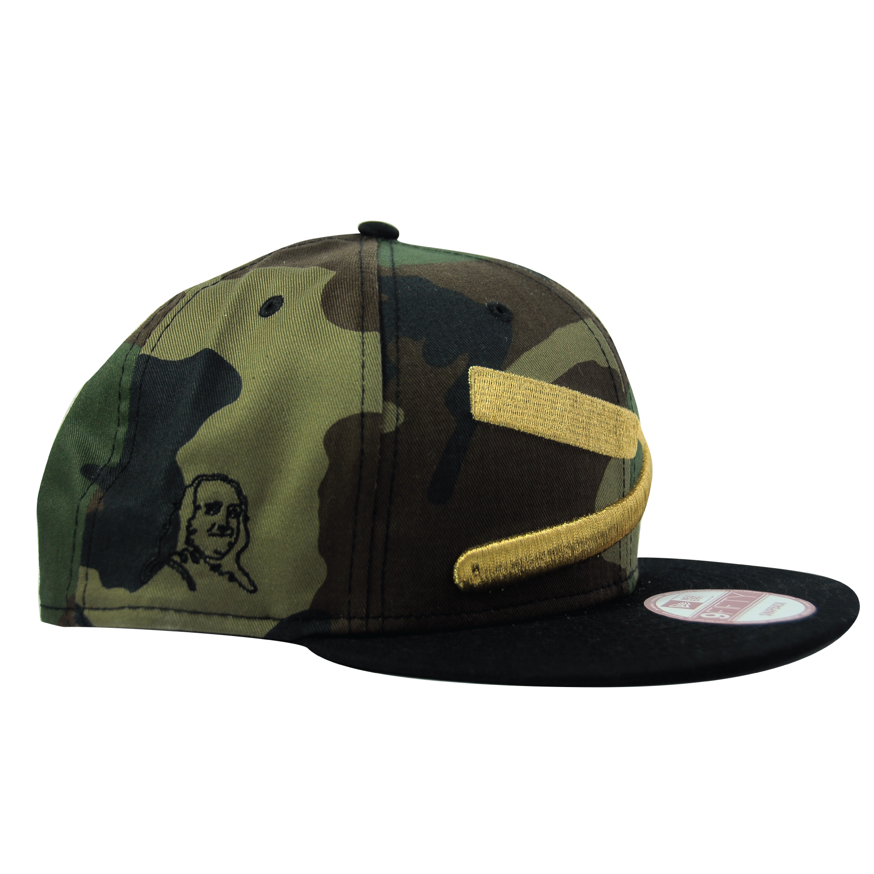 Camo baseball cap with gold embroidered accents and a black brim, featuring a small embroidered face and a gold patch.