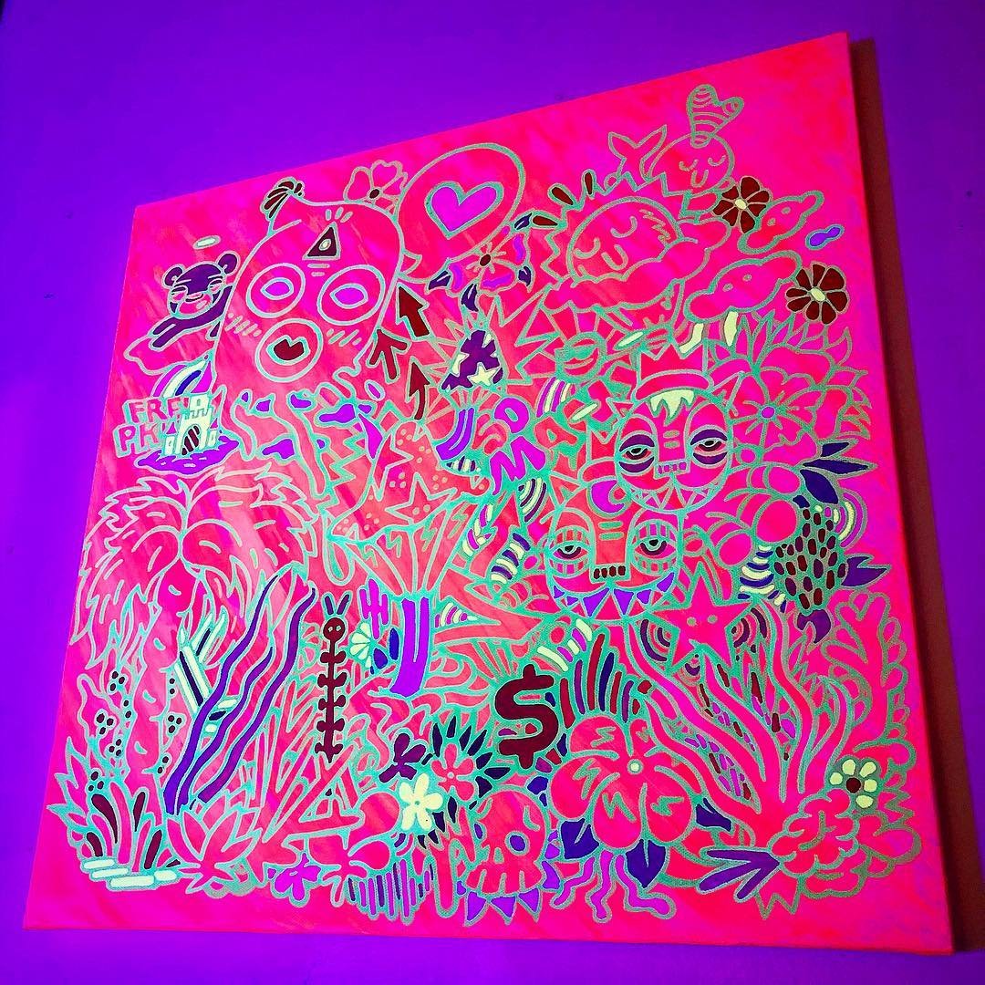 Colorful neon art with various abstract doodles, faces, animals, and symbols on a pink background, illuminated under blacklight.