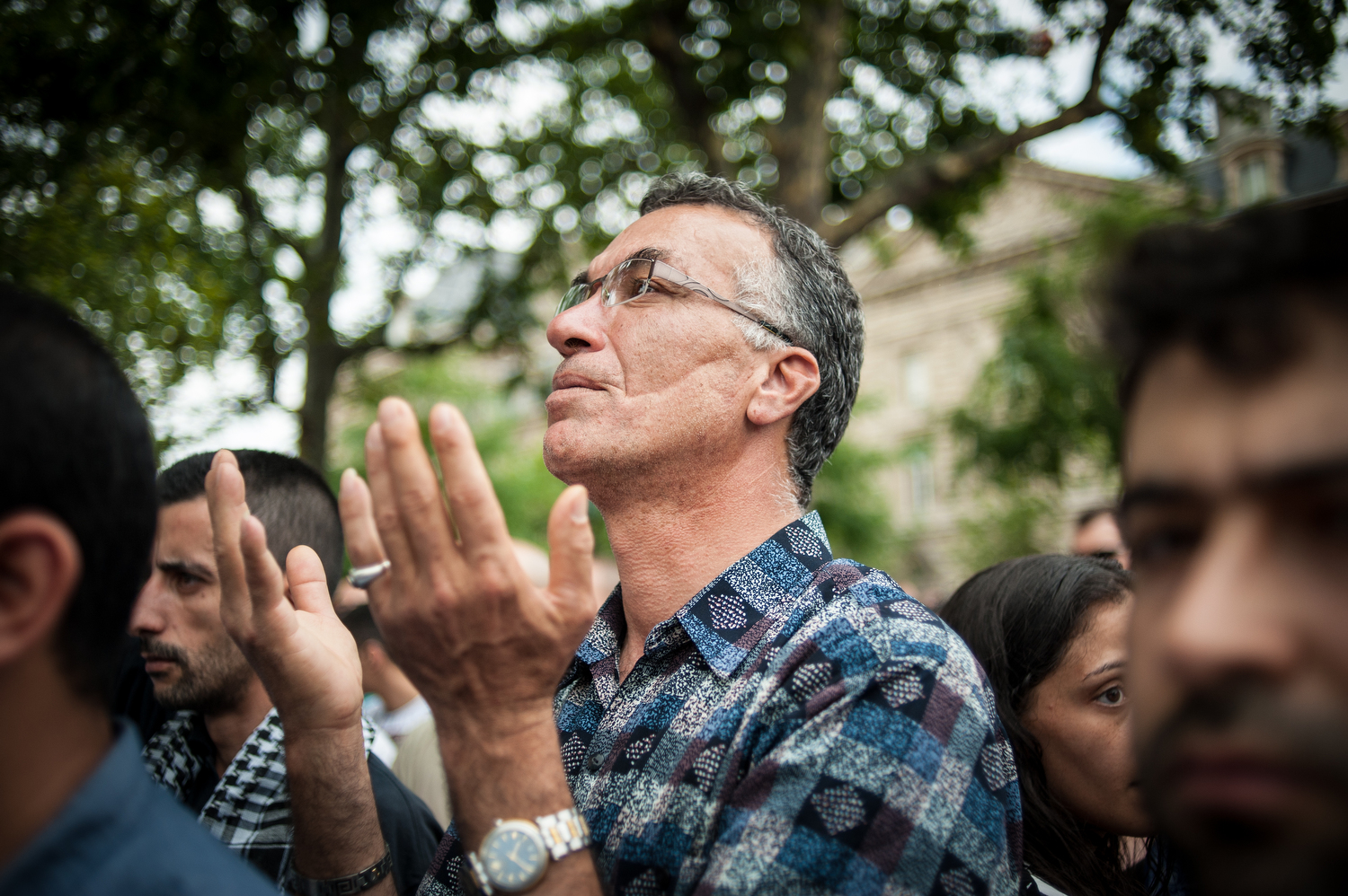  A man prays during the demonstration at Place de la Republique 