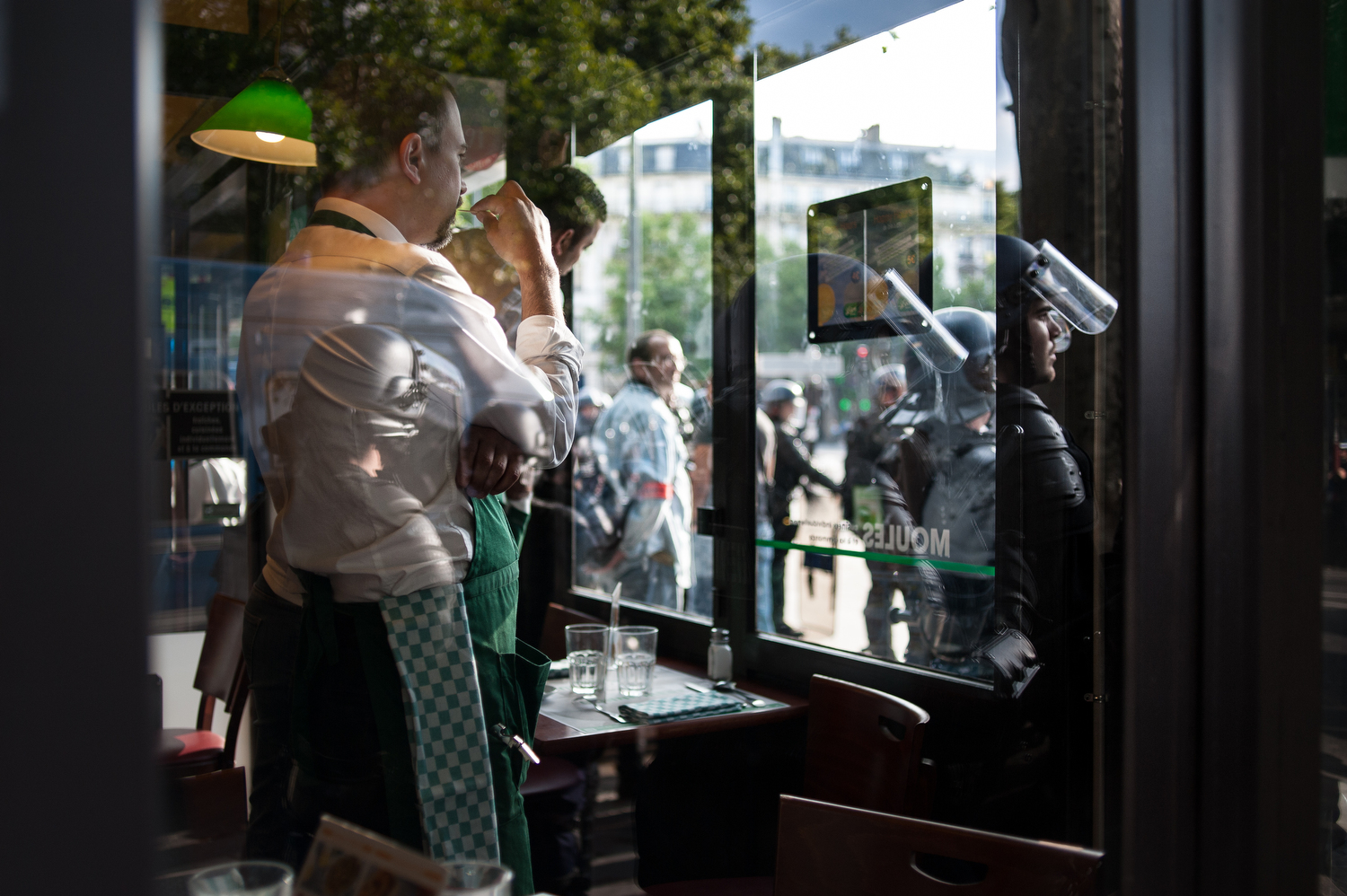  A server at the restaurant Leon on Place de la Republique watches the demonstration. 