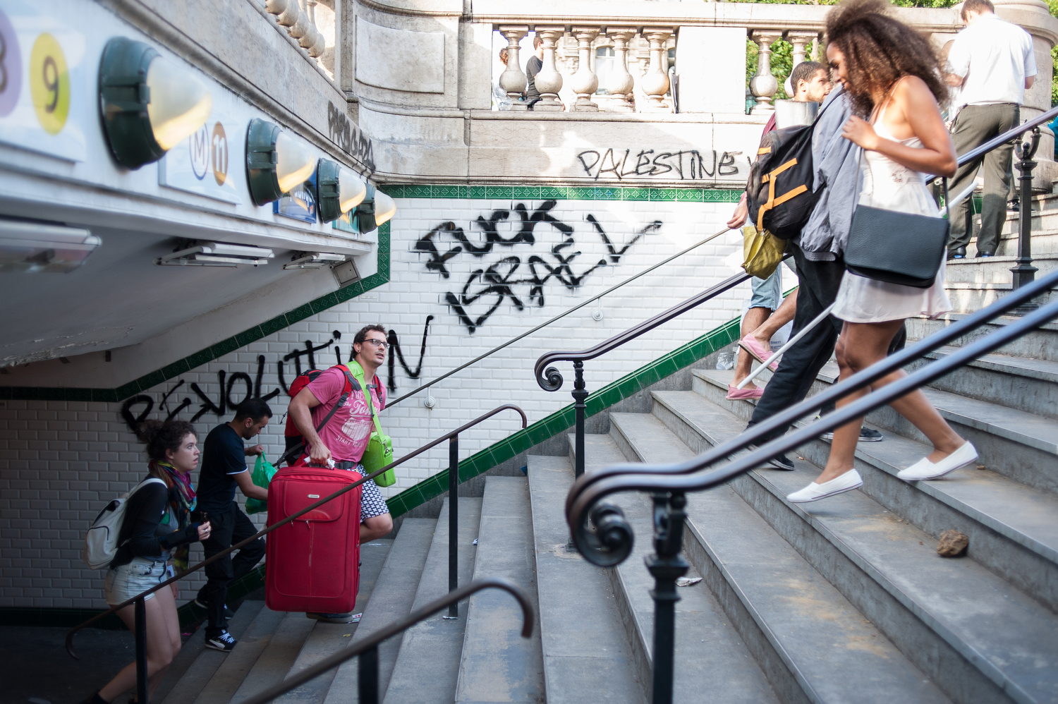  After 19h30, calm returned to the Place de la Republique and the metro, which had been vandalized, was reopened. Tourists carry their bags out of the metro station. 
