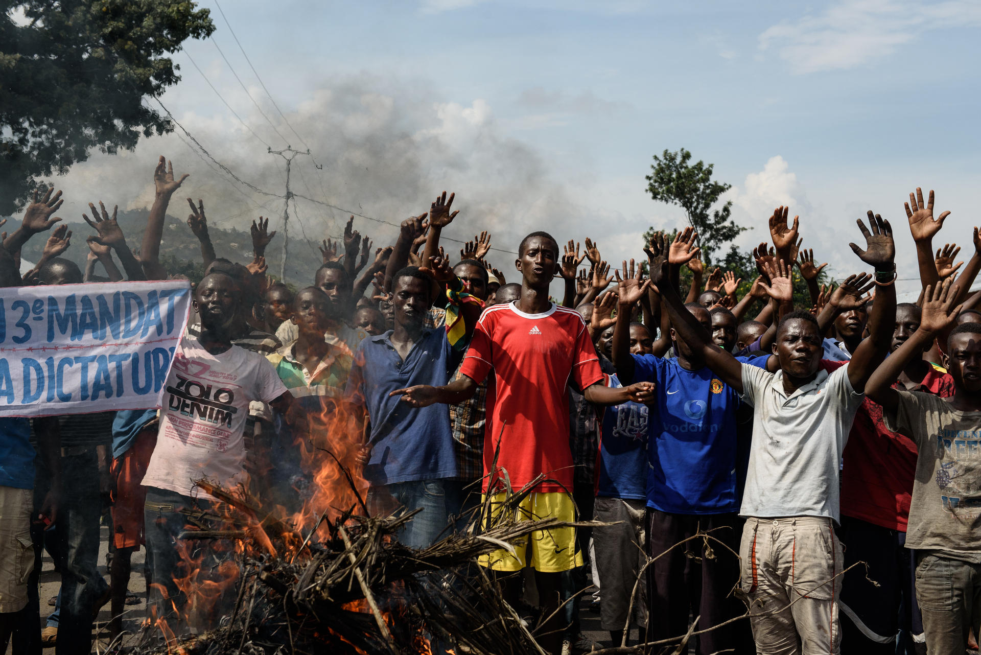  People sing the Burundian National Anthem in Musaga behind a barricade fire. Protests of Nkurunziza's controversial 3rd term bid continued on Monday 18 May in Musaga, Bujumbura. 