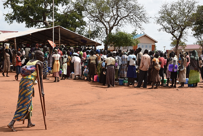 People line up at the food distribution center at Nyumanzi refugee transit center near Adjumani, Uganda on 23 September 2016. Since the escalation of violence in South Sudan in July, one million South Sudanese refugees have fled into neighboring countries, with over 373,000 in Uganda. Nyumanzi refugee transit center houses 3,474 refugees who will be transferred to the nearby settlement next week.