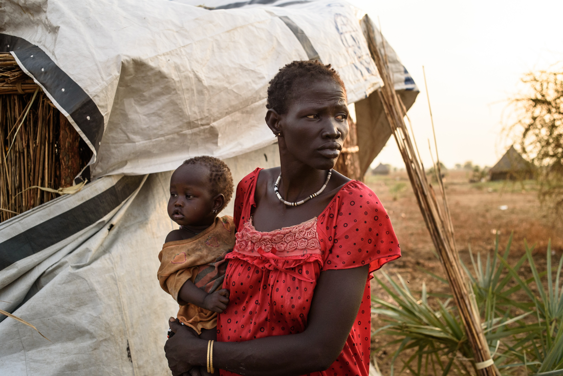  Chuong Majiok Chuol, 41, holds her child, Nyajieck. This family fled from Koch to Nyal in August 2015, and are living on the outskirts of Nyal, South Sudan.  