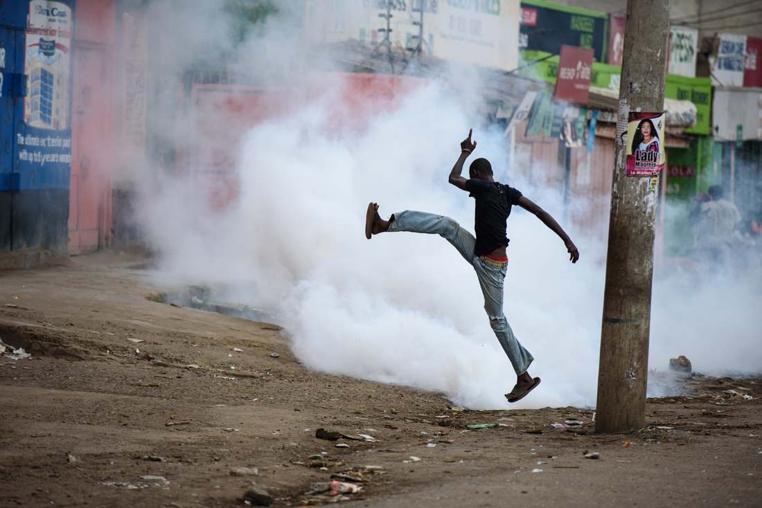  A protester jumps through tear gas during a face off with anti-riot police in Kondele, Kisumu, Kenya on 25 October 2017. 

 
