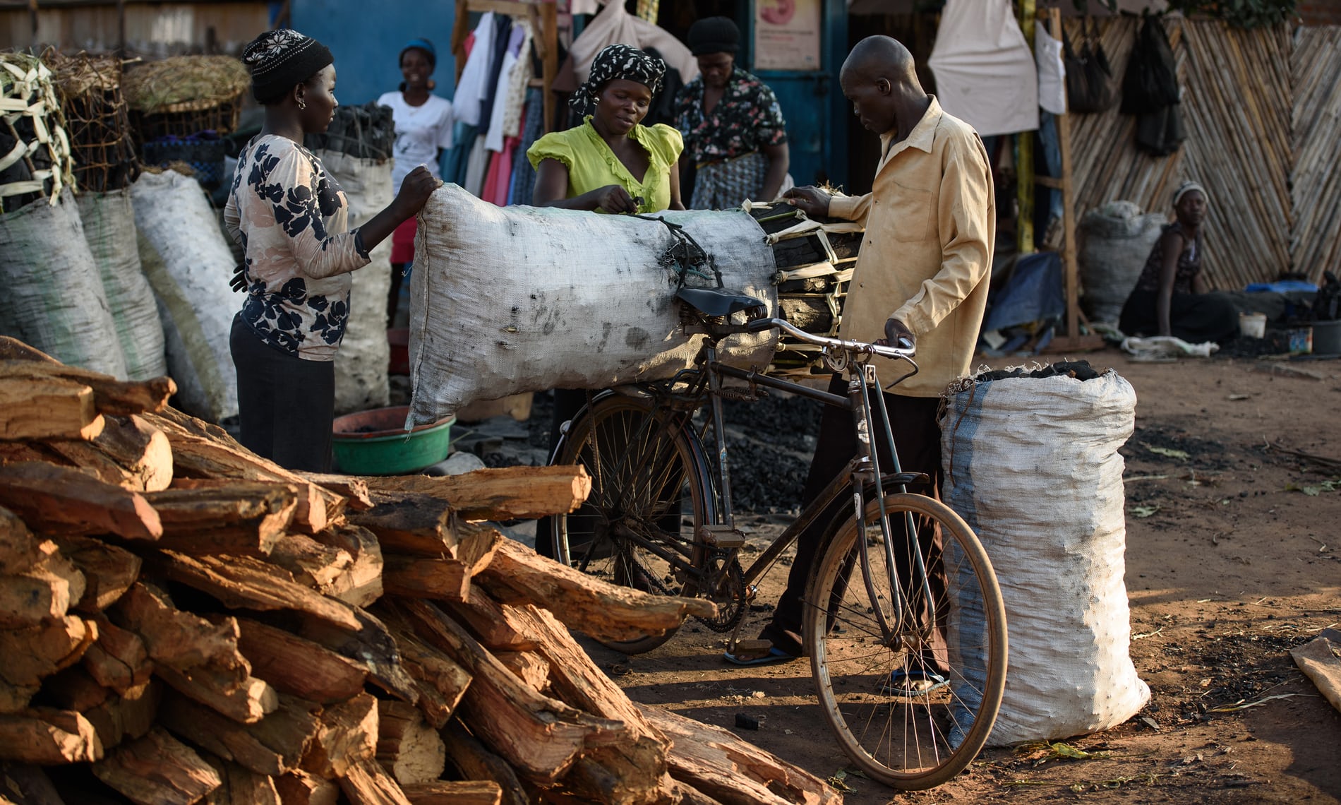   A man buys charcoal from a vendor in the market in Gulu. 