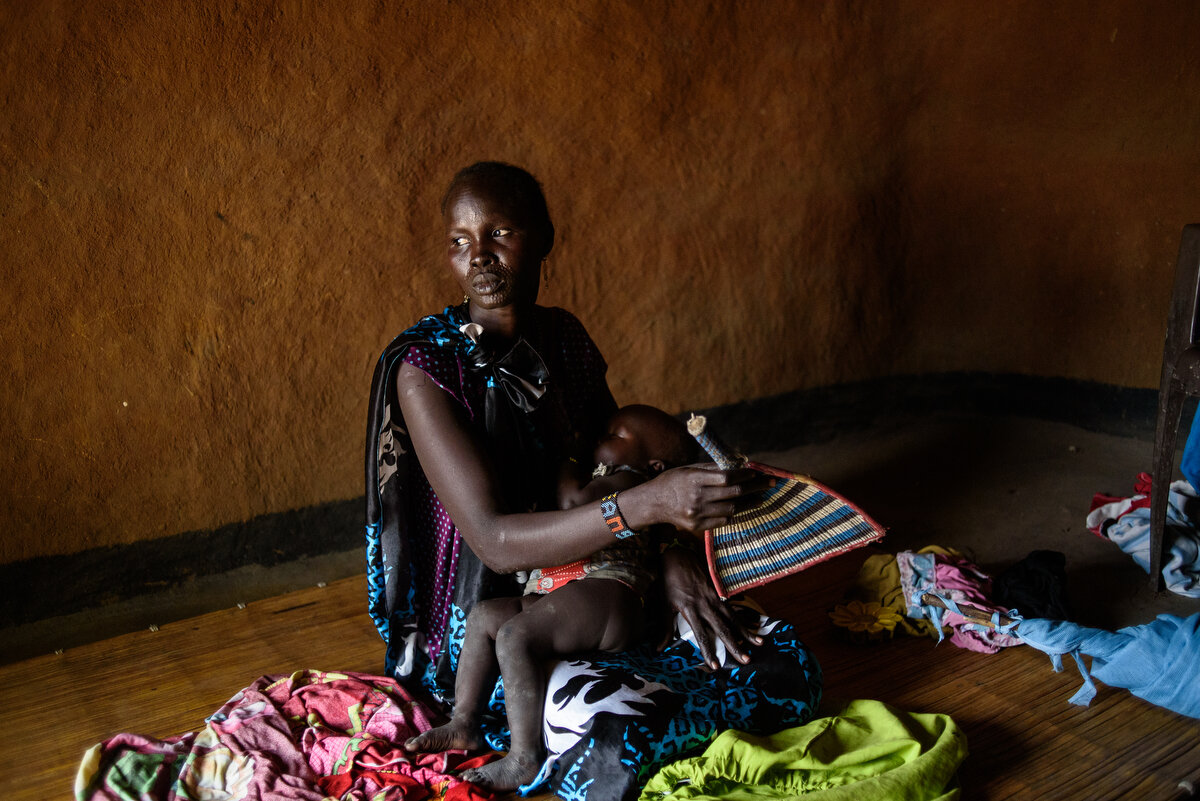  April 2017, Nyal, South SudanAngelina comforts her baby, NyaladuAngelina Nyadoang Juack, 38, with her children Nyawiech, 14, (flowered dress), Nyachiot, 6, (black and pale stripes with flowers dress ) Nyathoar, 7 (pink dress), Beah, 4, (ripped vest 