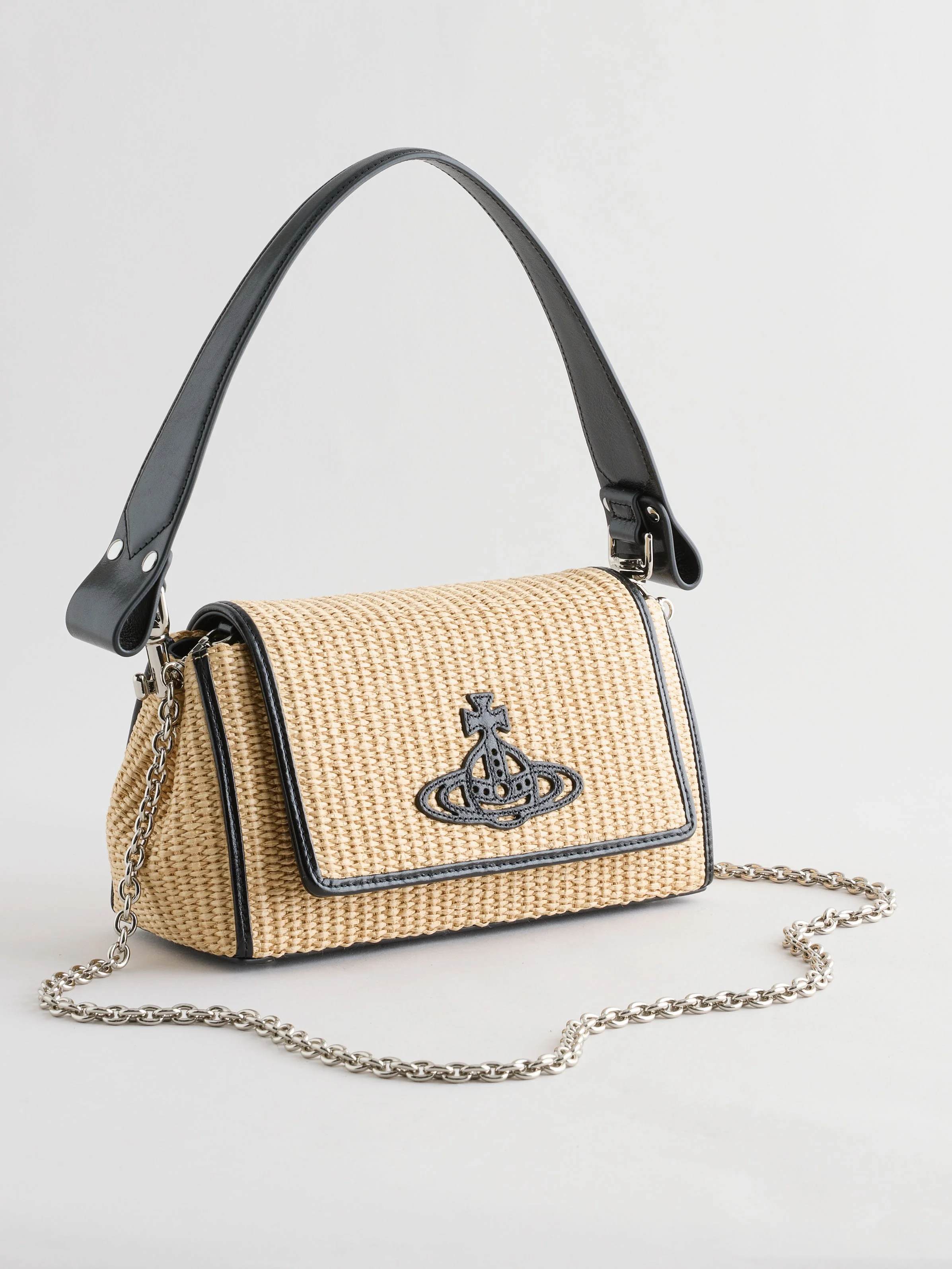 A woven beige handbag with black accents, a chain strap, and a black logo emblem on the front.