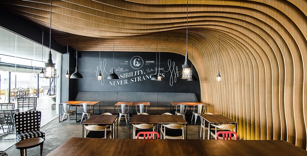 OOZN DESIGN has created cavernous cafe in Jakarta - Six Degrees Cafe using undulating timber slats around the walls and ceiling to make a memorable and cosy cafe. 
