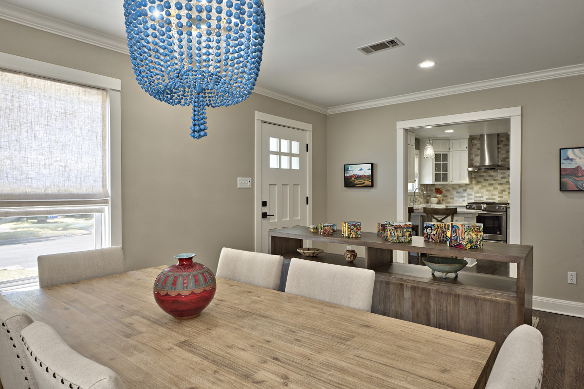 The front living space was transformed to an entry way and dining area, separated by a two-sided console. This new, airy floor plan along with an open entryway to the kitchen, provides the perfect scenario for welcoming and entertaining guests. The mood of each room was lifted with new lighting throughout; including a whimsical blue beaded chandelier over the dining table (seen here), practical (yet beautiful) task lighting under areas like kitchen cabinets, and broader, clean recessed lighting that gives a sense of daylight throughout the space. 