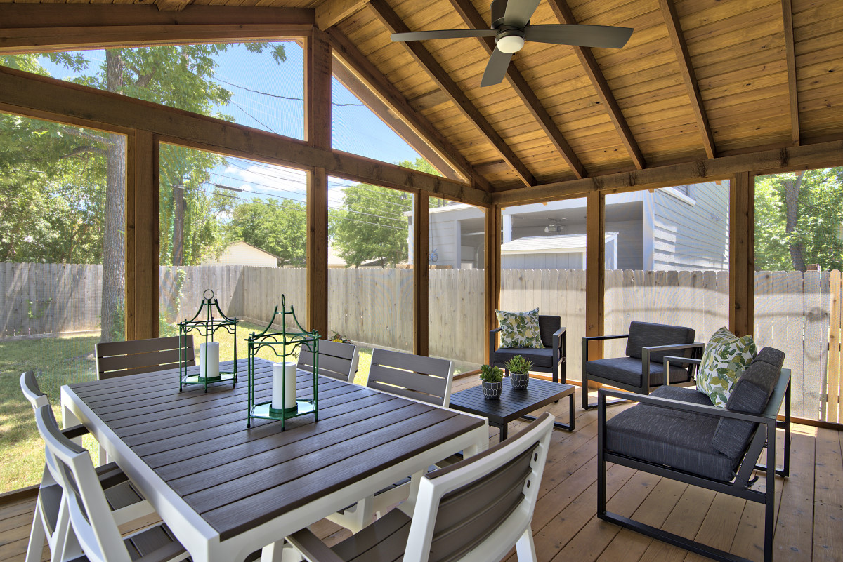 New furnishings for the existing screened-in porch add a touch of modern that sets off the rustic feel of the raw wood structure. Furniture placement allows for easy conversations and casual outdoor dining, while the nature inspired accessories pull the outside in.
