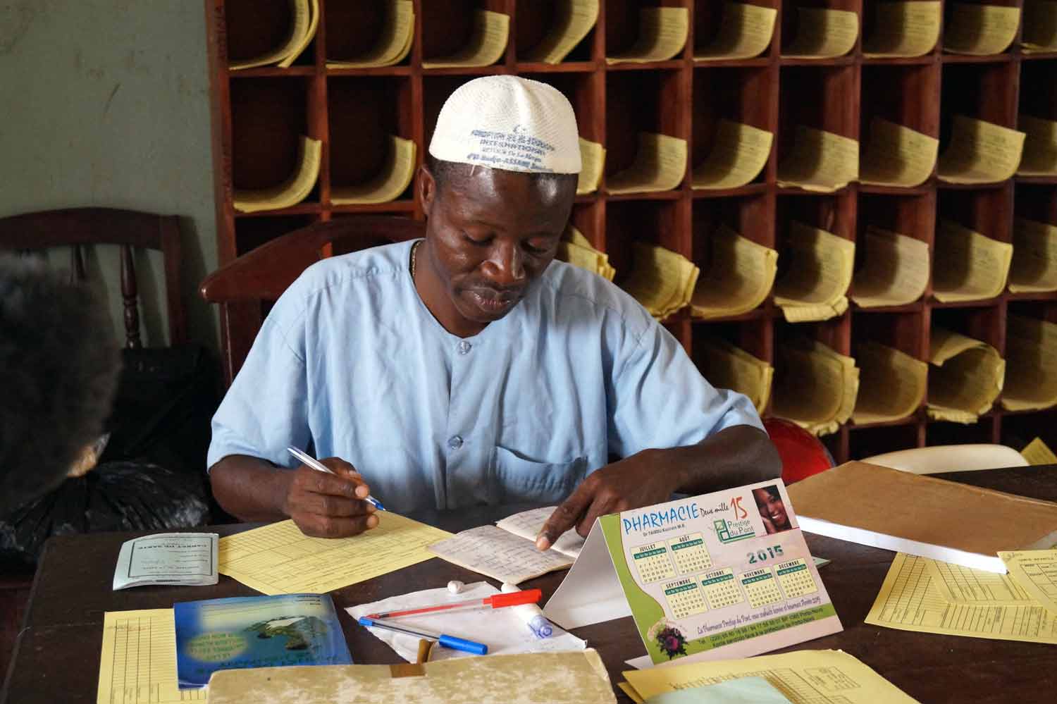 A health worker sorts through paper records. Source: VaxTrac.com