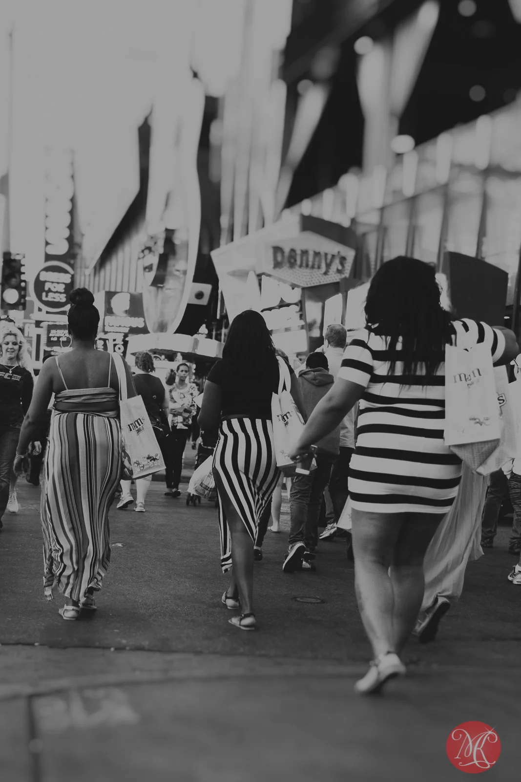 las vegas three women in striped dresses crossing the street carrying m&m candy bags