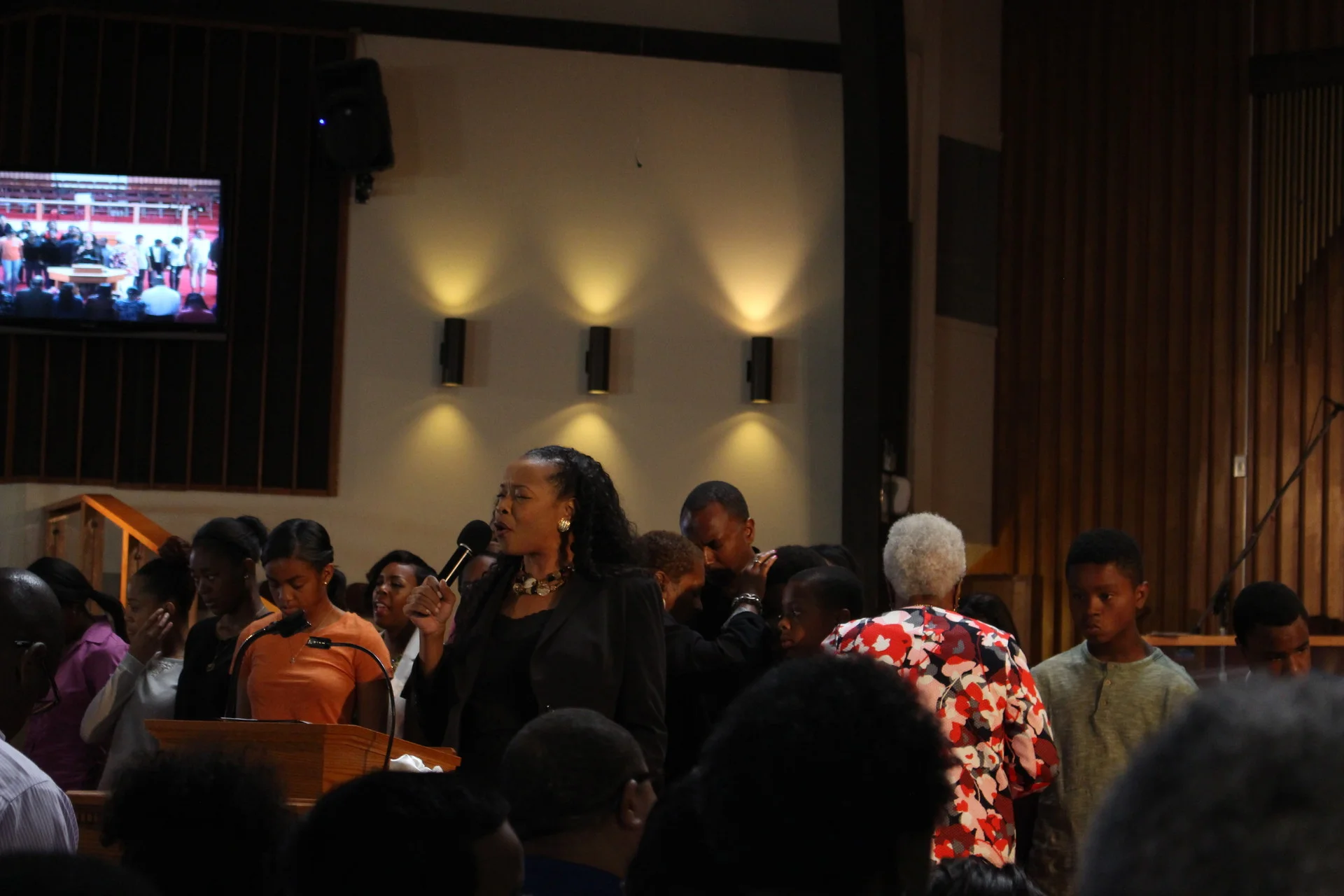 The Rev. Jacqueline Thompson leads prayers at the Allen Temple Baptist Church for those killed during shootings last week by and against police. (Farida Jhabvala Romero/KQED)