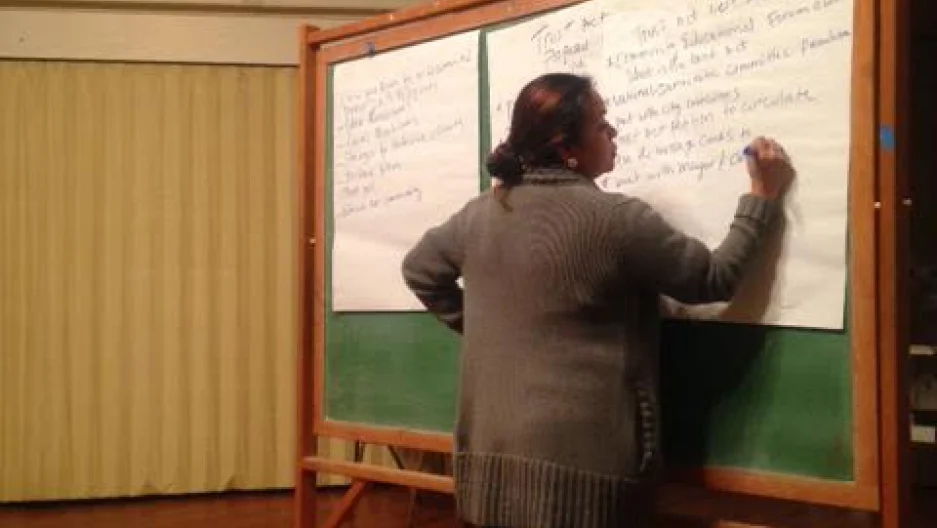 Isabel Lopez takes notes at a meeting in a church to discuss immigration issues in Brockton, Massachusetts. Credit: Lidia Jean Kott