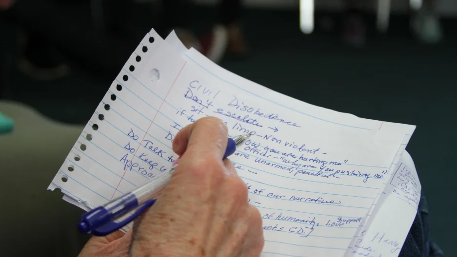 An attendee of a training session in Las Cruces, New Mexico, takes notes about how to best protest immigration operations. 136 people attended the training, many of whom pledged to be arrested if needed to try to stop federal agents from deporting their neighbors. Credit: Simon Thompson/PRI