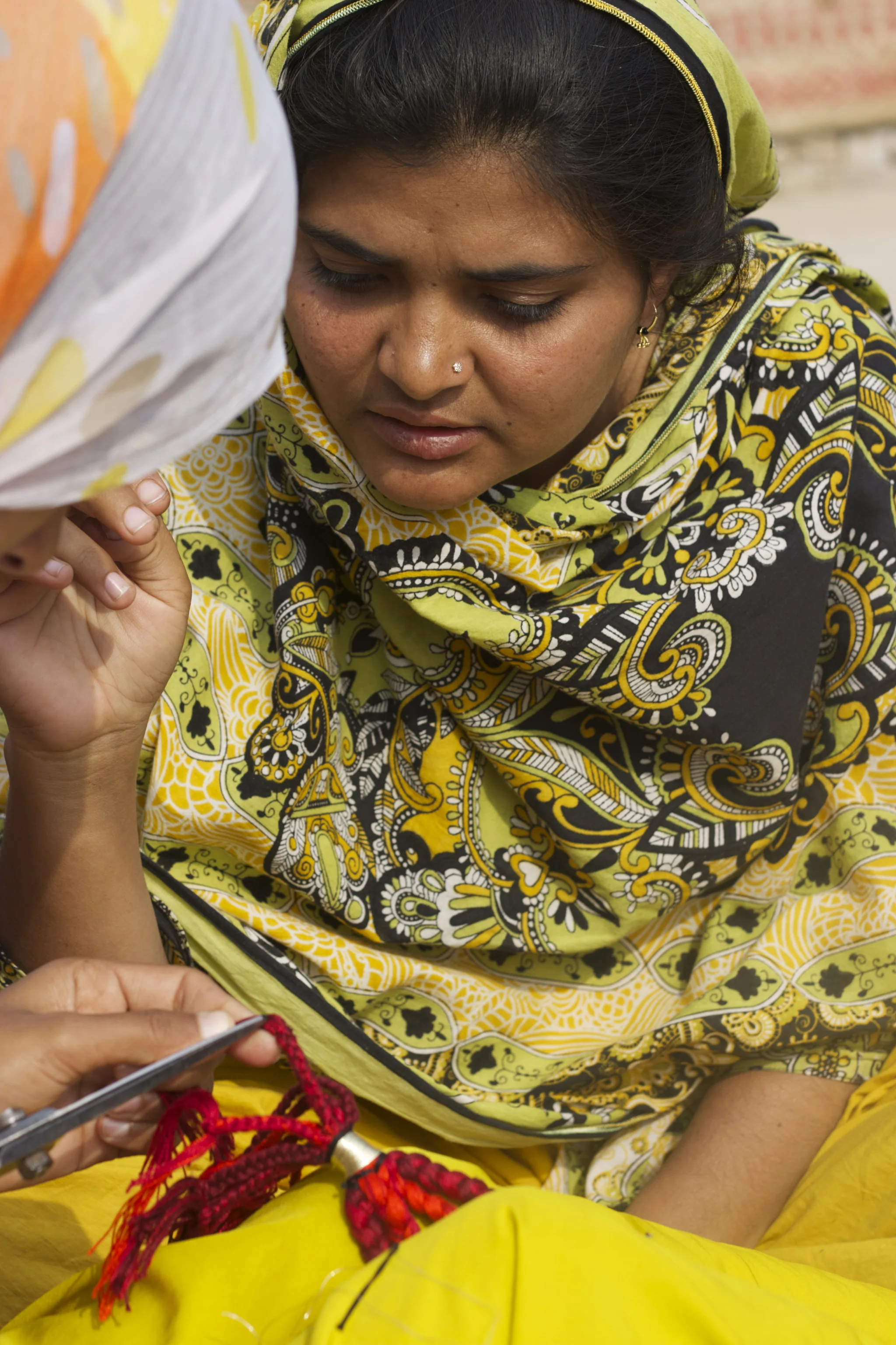 Bhaitan looking on as Shamim finishes off Red Ombre necklace January 2015