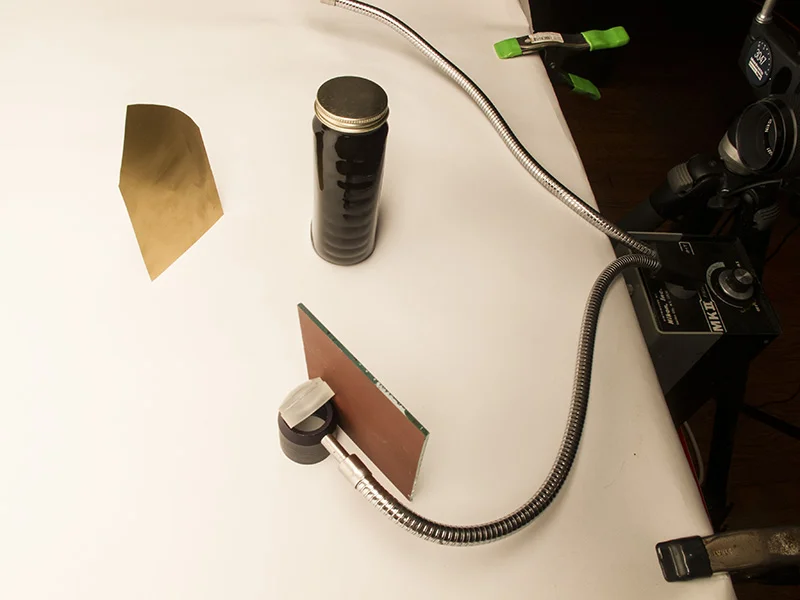 Here you can see the Nikon fiber optic light which is shinning through a lens. The lens focuses the light onto the reflective paper behind the bottle and shines through the product towards the camera.