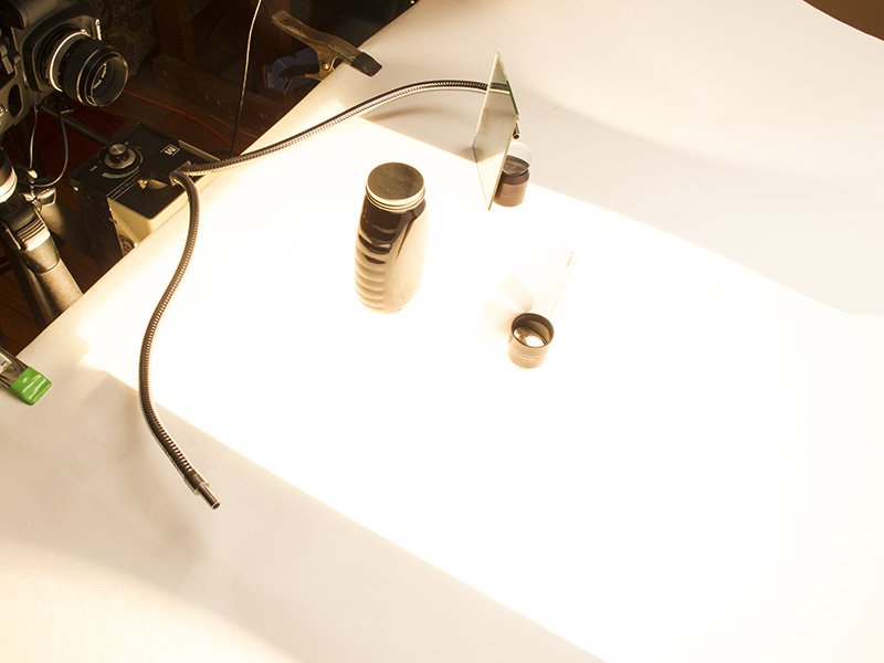 The tabletop is glass covered with pure white paper. Underneath is a strobe with a 1/2 CTO gel to match the fiber optic's light temperature. 