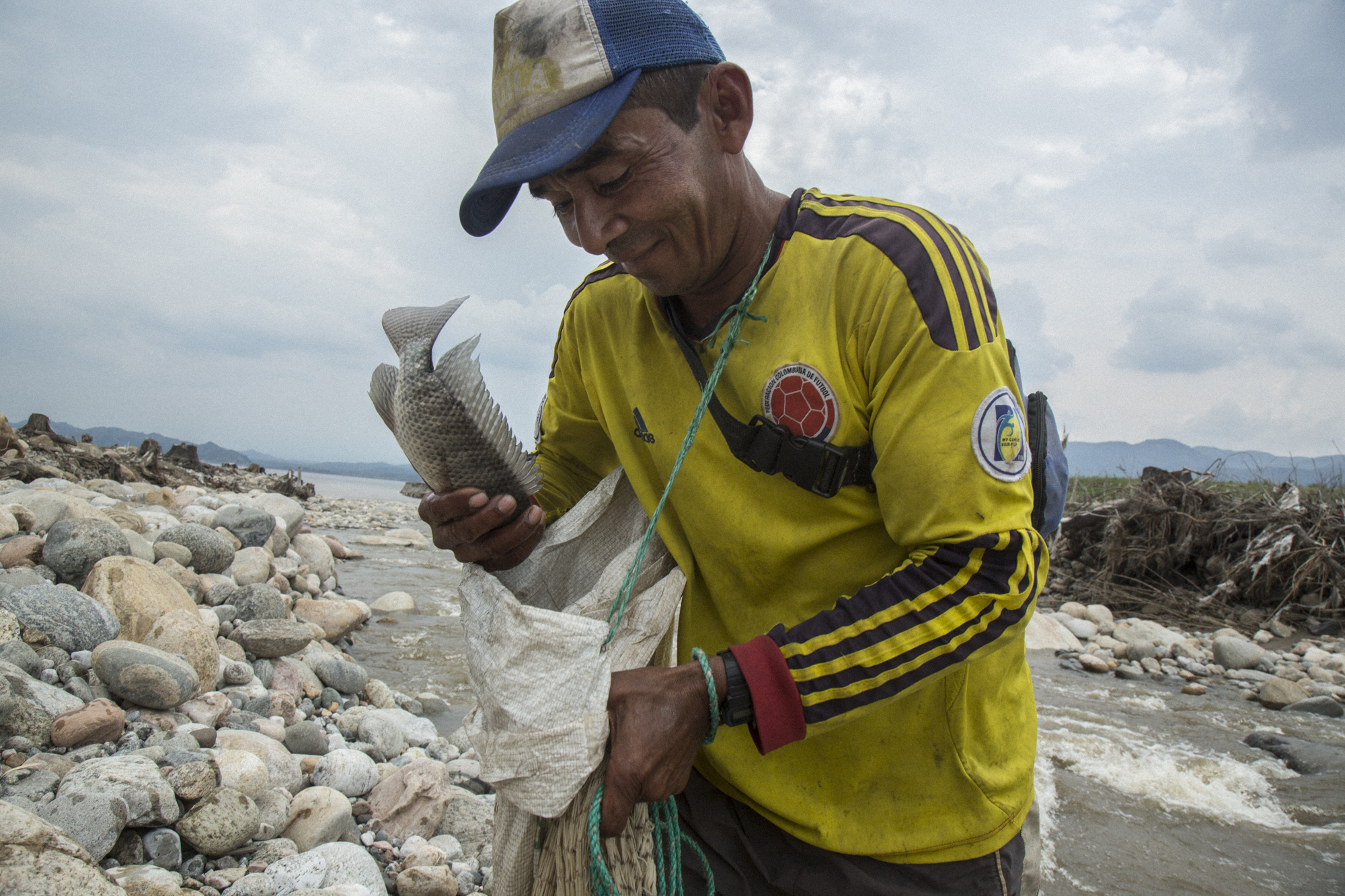  A fisherman manages to catch a fish in a flooded tributary river that used to flow through forest into the Magdalena River, but now dies in the reservoir created by the Quimbo dam, greatly reducing the fish population due to algae blooms and disrupt