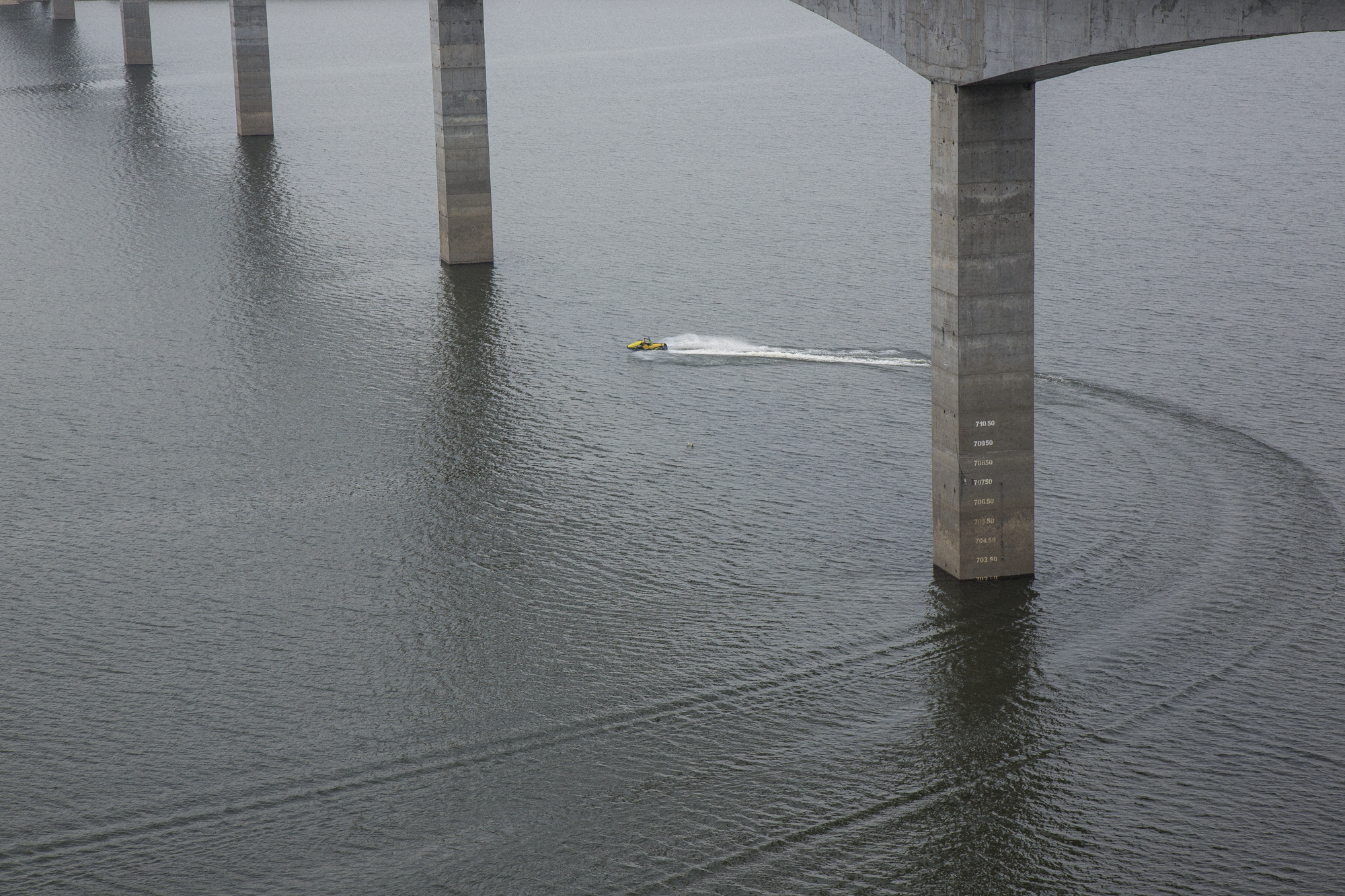  A jet ski passes under a recently constructed bridge running over the Quimbo dam reservoir that fills the Magdalena river valley near the town of Las Jaguas, Huila, Colombia. March 18, 2017 