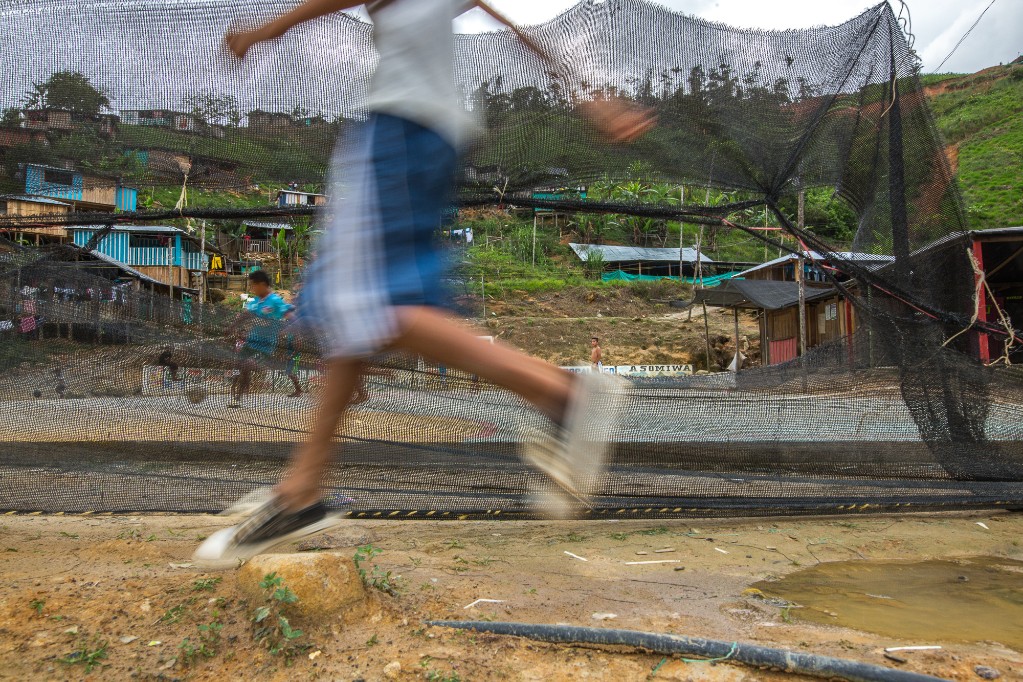     Kids play soccer on the court made by the mining companies and the ASOMIWA cooperative in the middle of the community. Mina Walter, Sur Bolivar, Colombia. May 12, 2017 