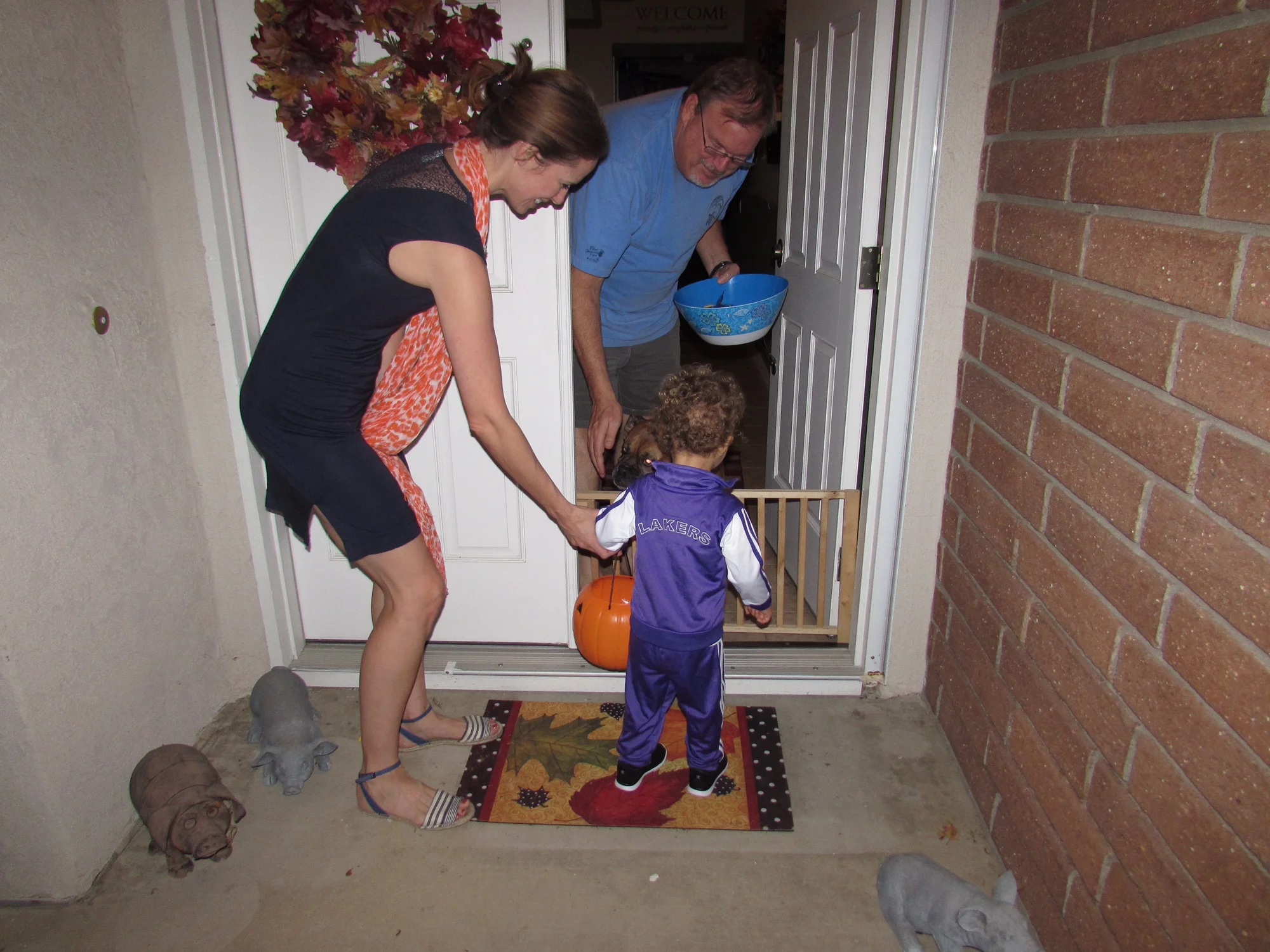 He wasn't sure which was better, the candy or the big dog on the otherside of the gate. Or those pig figures on the porch, lol.
