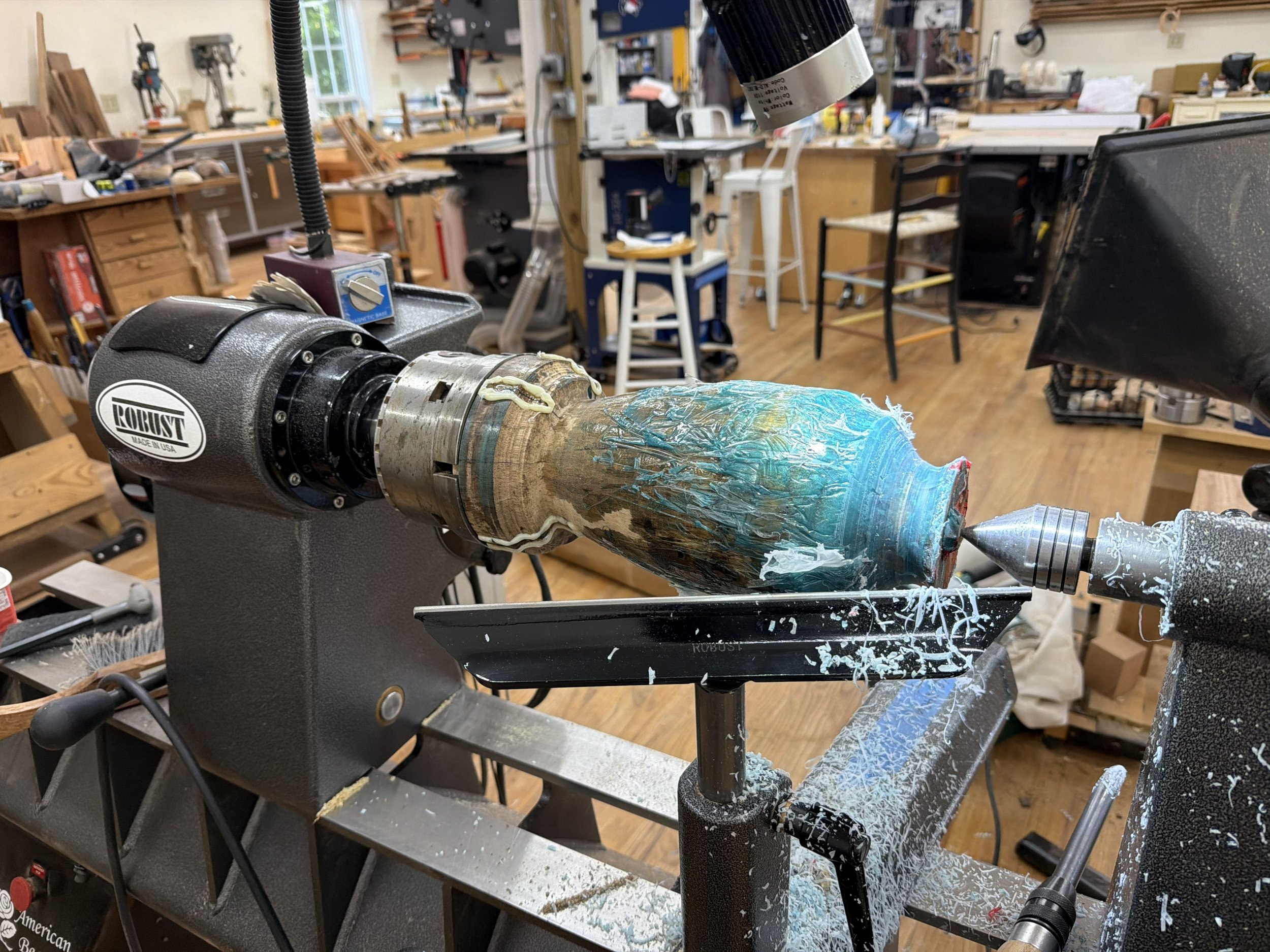 Persimmon form on the lathe coated with blue resin during a second stabilization casting.