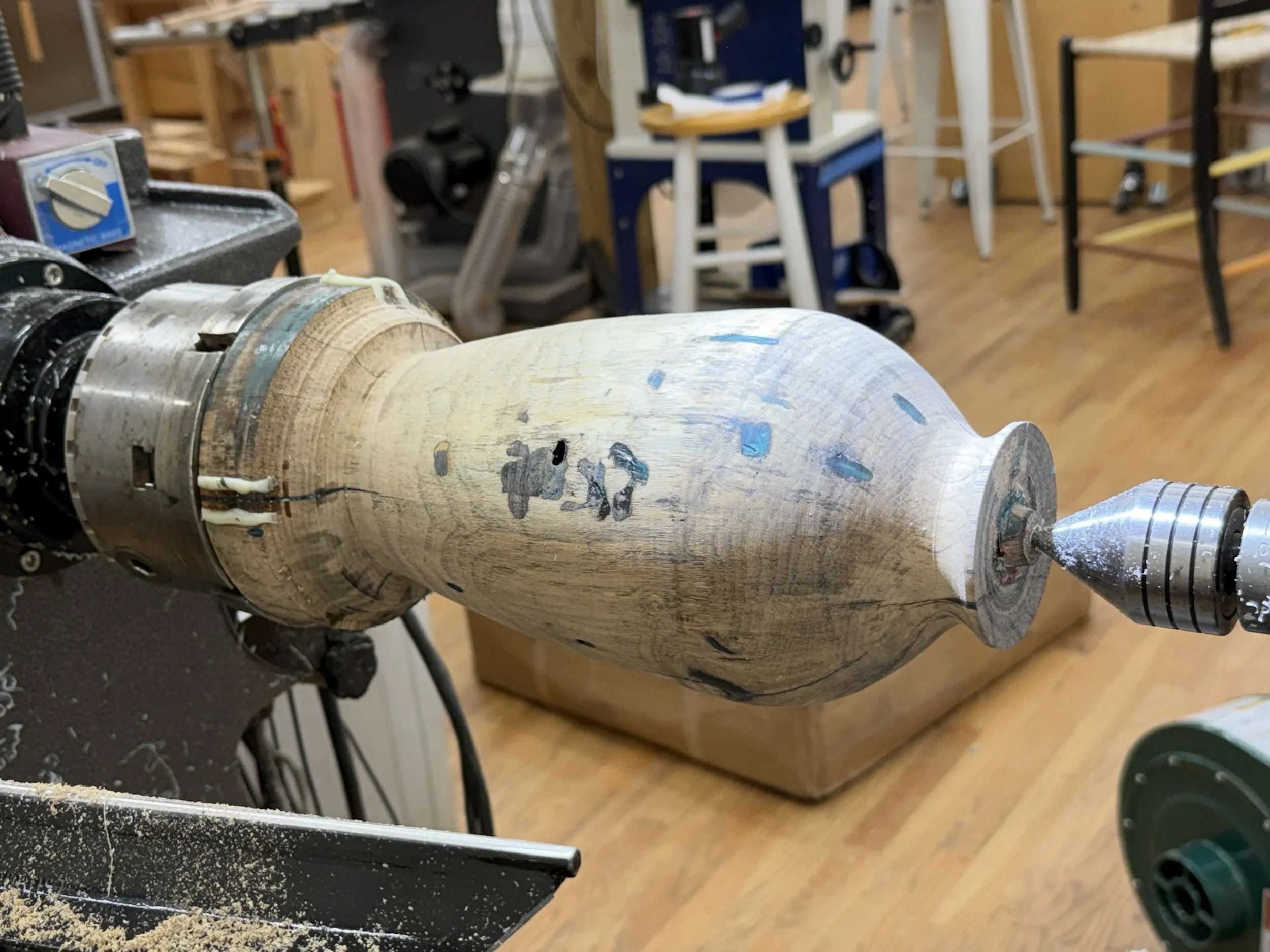 Refined persimmon hollow-form shape on the lathe after excess resin was turned away.