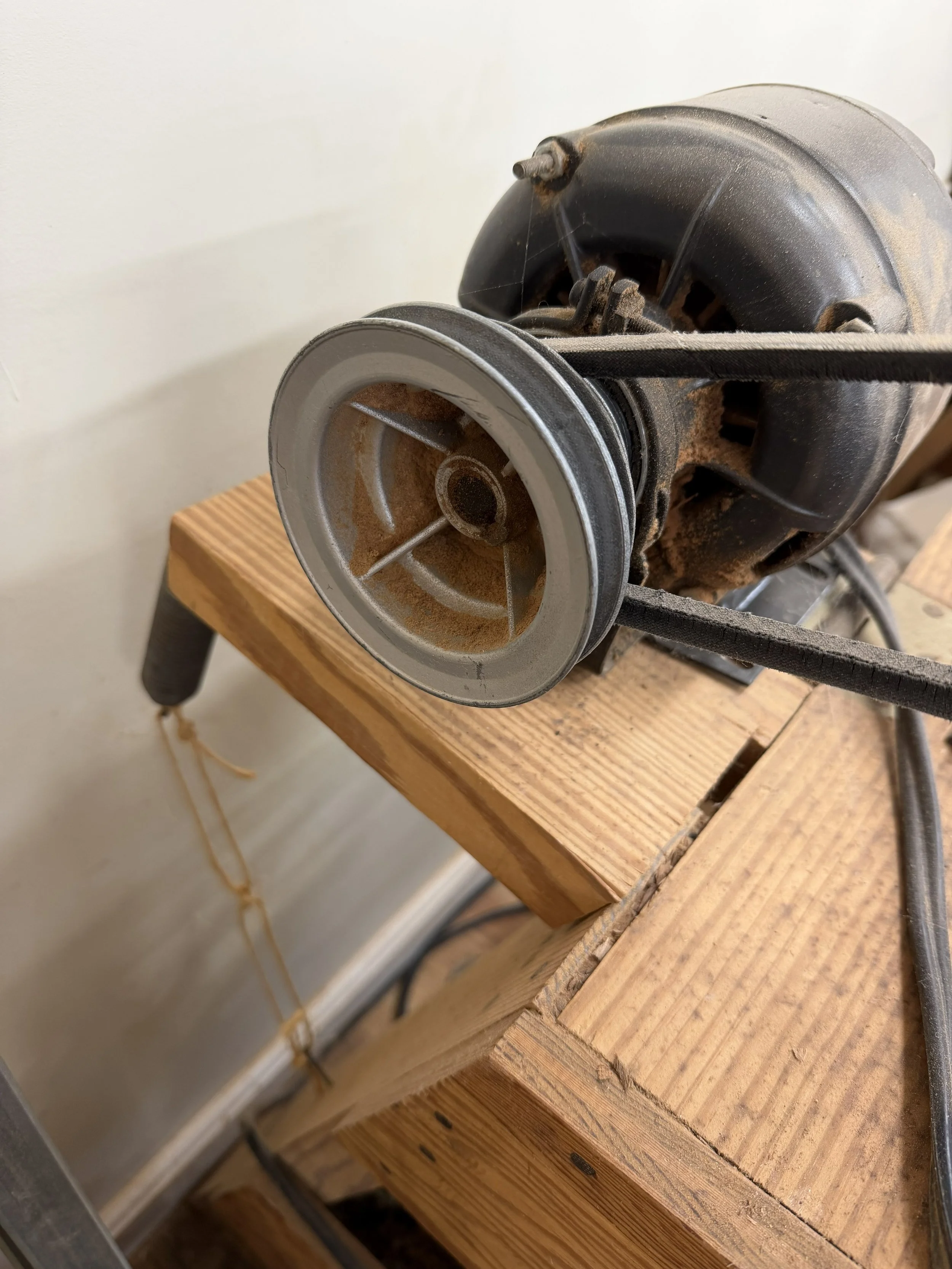 belt driven motor of woodlathe with baling twine holding tension between a spring and a nail.