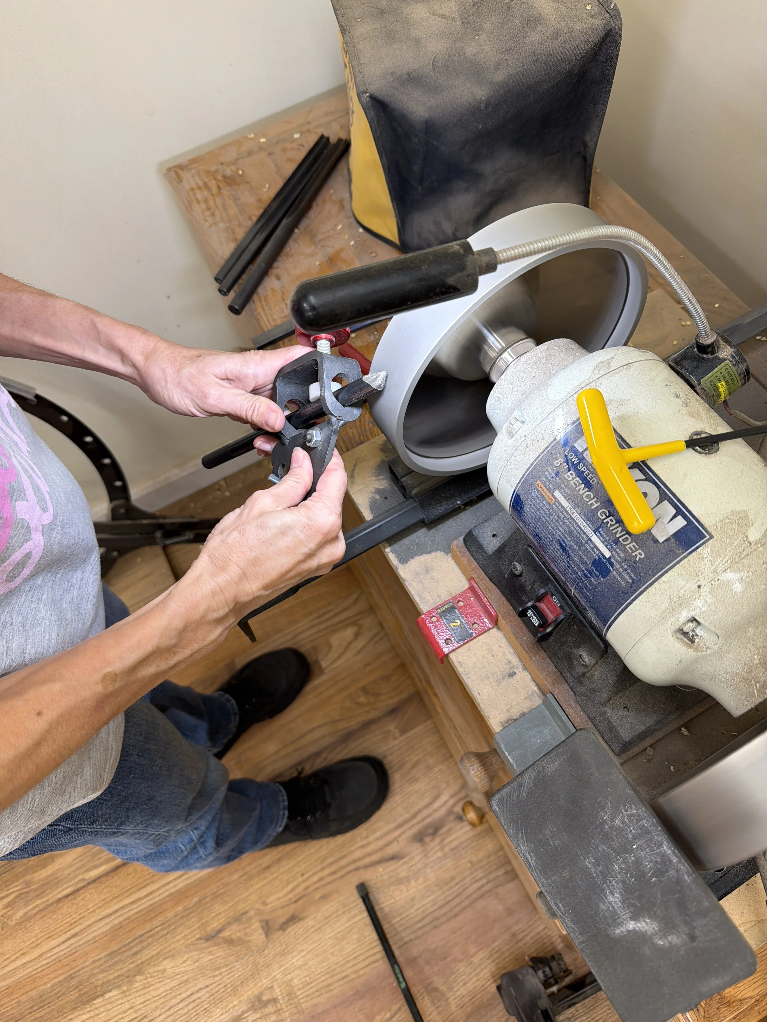 Rebekah Gunn sharpening a woodturning tool at the grinder in her workshop.