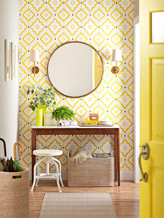  Brighten up your entry with a mirror, sconces a yellow door and some bright wallpaper. Image via Centsational Girl