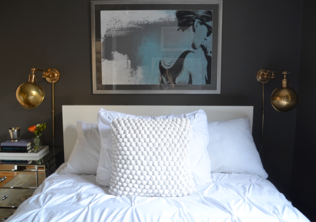 The all-white but textured bedding provides interest and the bedside sconces are not only functional and space-saving but also add a touch of shine.