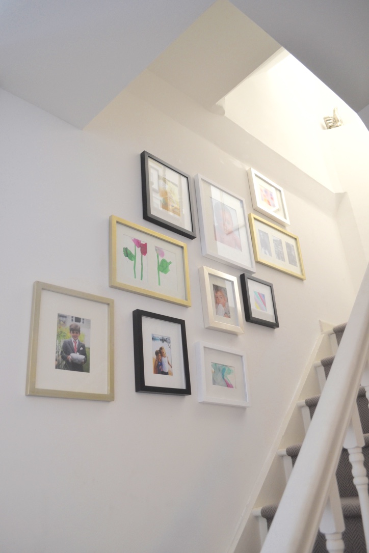 The use of black, white, silver and gold frames in different shapes and sizes provides an eclectic yet polished look.