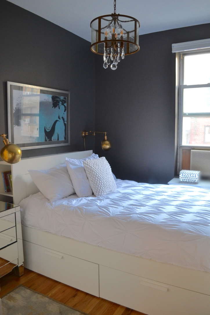The all-white bed and bedding really pops against the dark charcoal walls. Small space tip: using dark colors in small rooms often makes them appear larger - and in this case, glamorous!