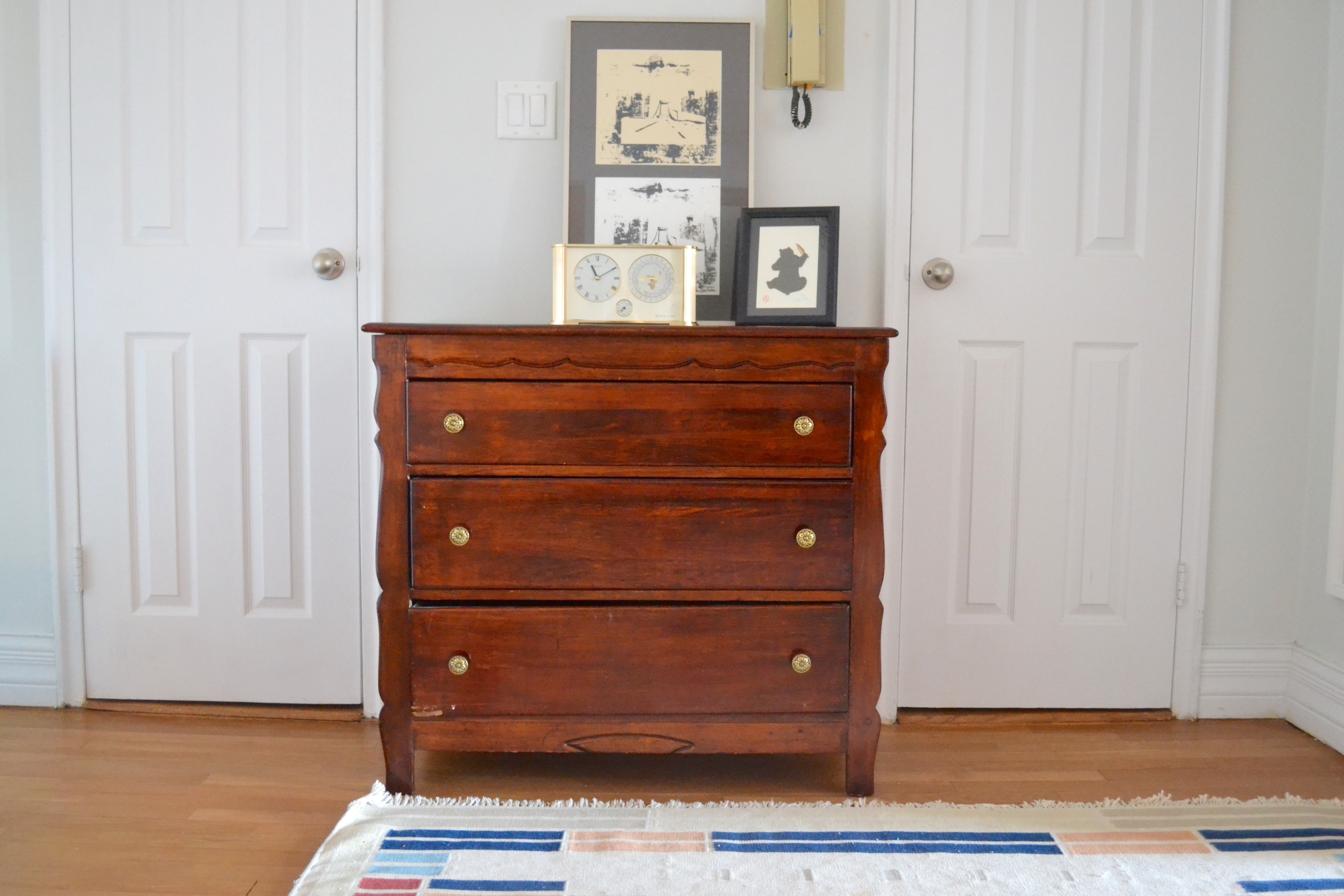 A previous bedroom dresser turned hall chest, topped with art collected by the couple is the perfect storage-providing accent.