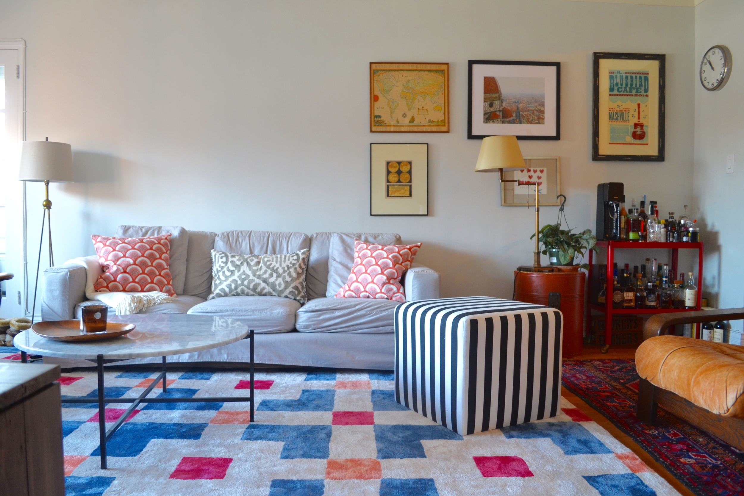 The slipcovered sofa is from Room and Board, the black and white cube is One Kings Lane. The area rug is from Anthropologie. The throw pillows were from fabrics Client Crafty and I picked out at Mood, and she sewed herself! The coffee table is a second hand find from AptDeco. The table lamp was a steal from Restoration Hardware Outlet.