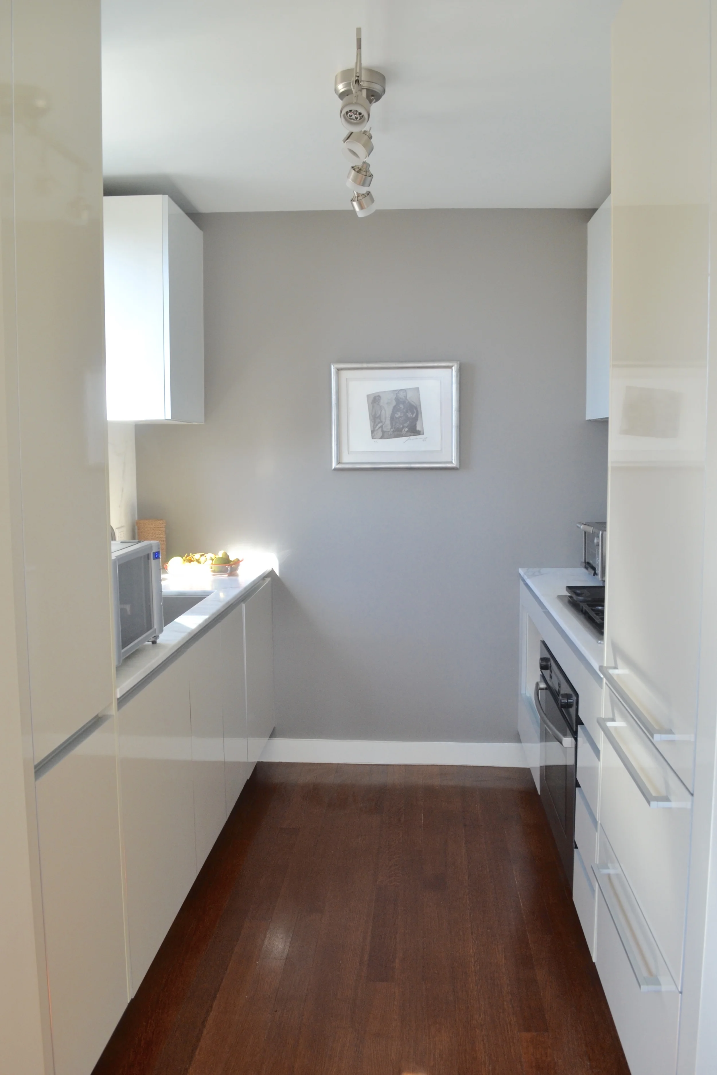 The kitchen is a mix of Carrera marble (a personal fav!) and beige and white lacquer cabinetry. As a nod to the gray in our living/dining scheme, we painted the wall gray. It pulled everything together, as the kitchen opens into the living space. 