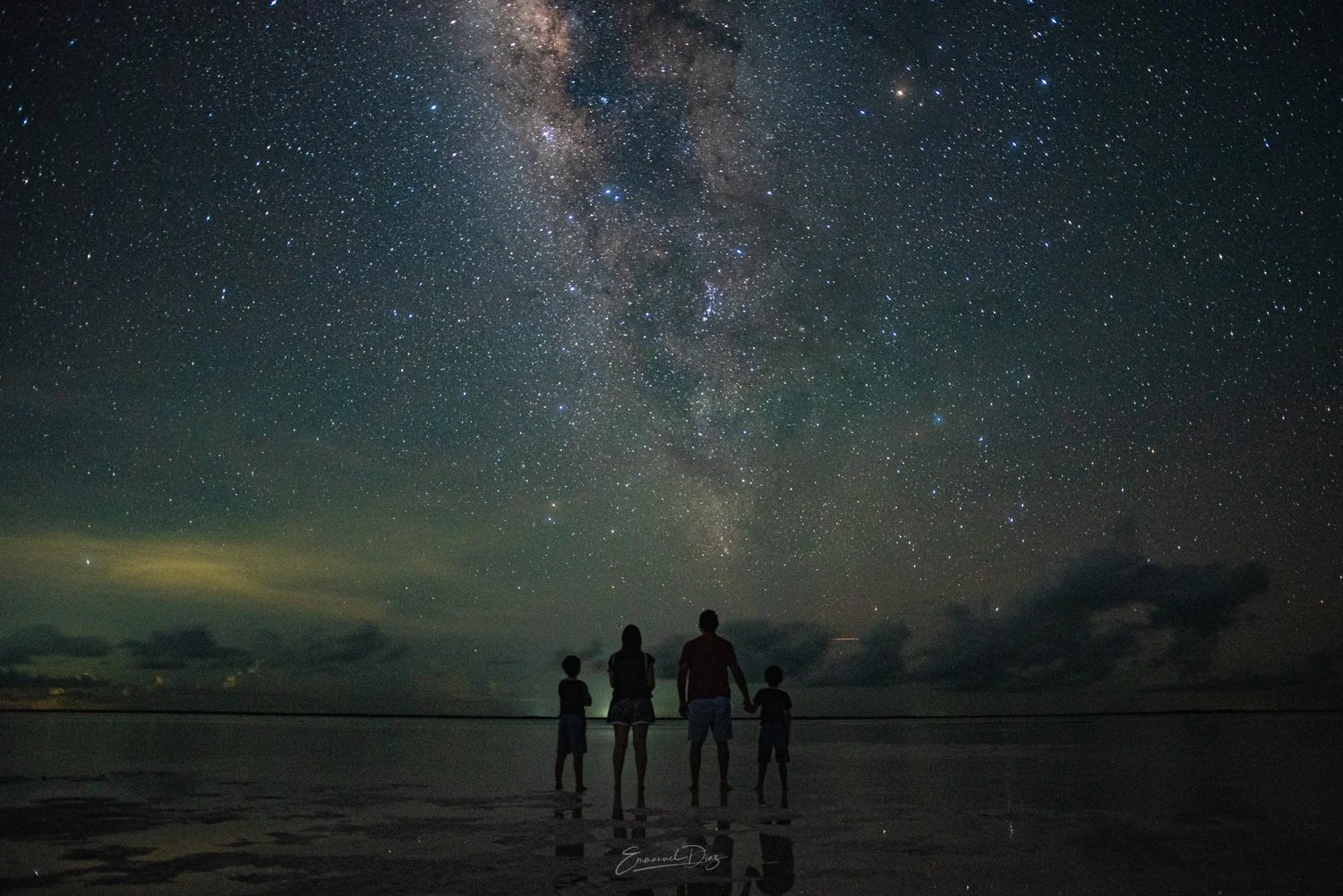 familia en punta cocos holbox haciéndose una sesión de fotos con la vía láctea de fondo, noche estrellada