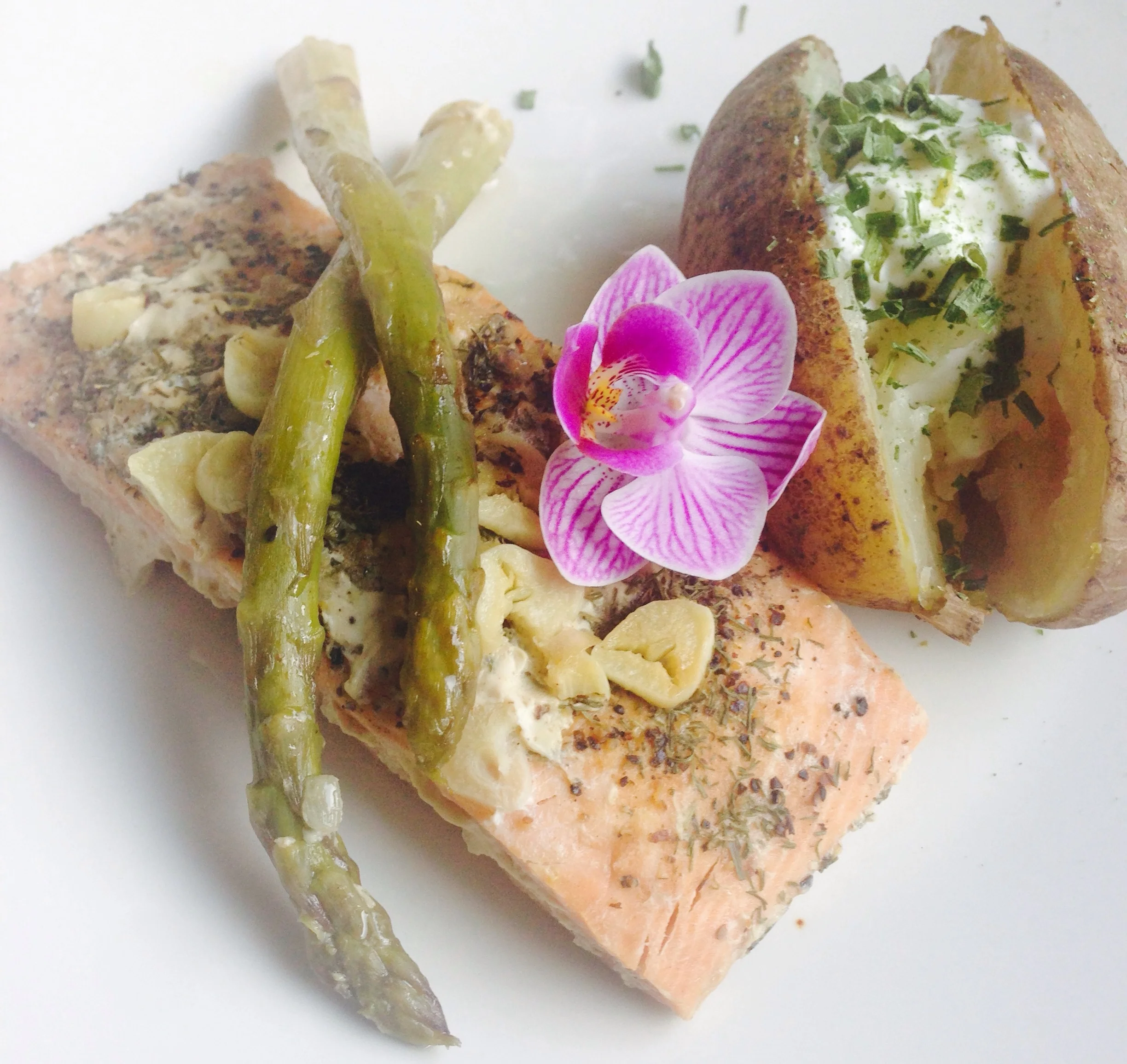 Herb crusted salmon with baked potato, crema & chive.